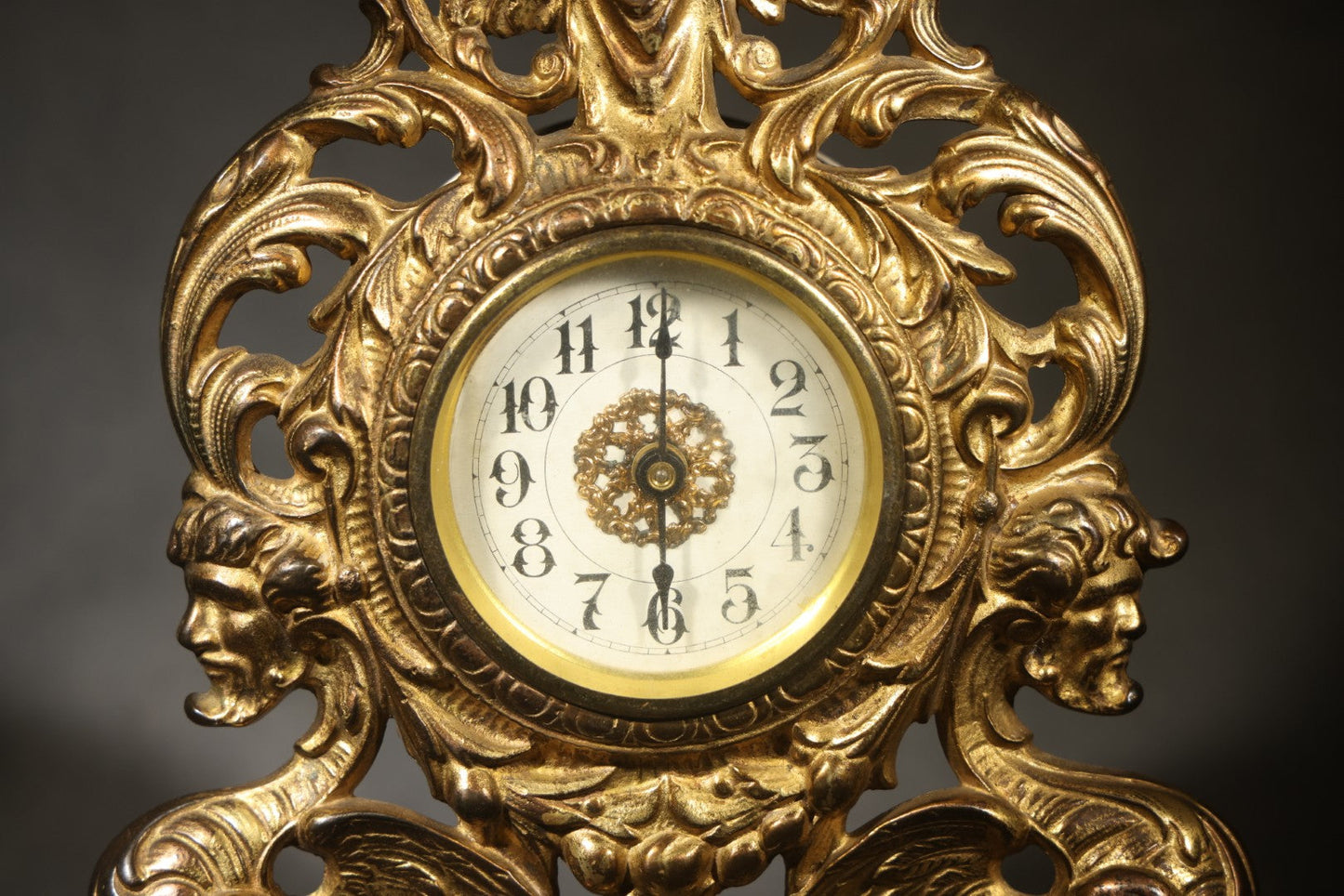 Antique Cast Brass Rococo Revival Style Mantel Clock with Winged Cherub, Grotesque Masks, and Scrolling Foliate Design, Signed A.F., Patented 1902-1908, Made in U.S.A.