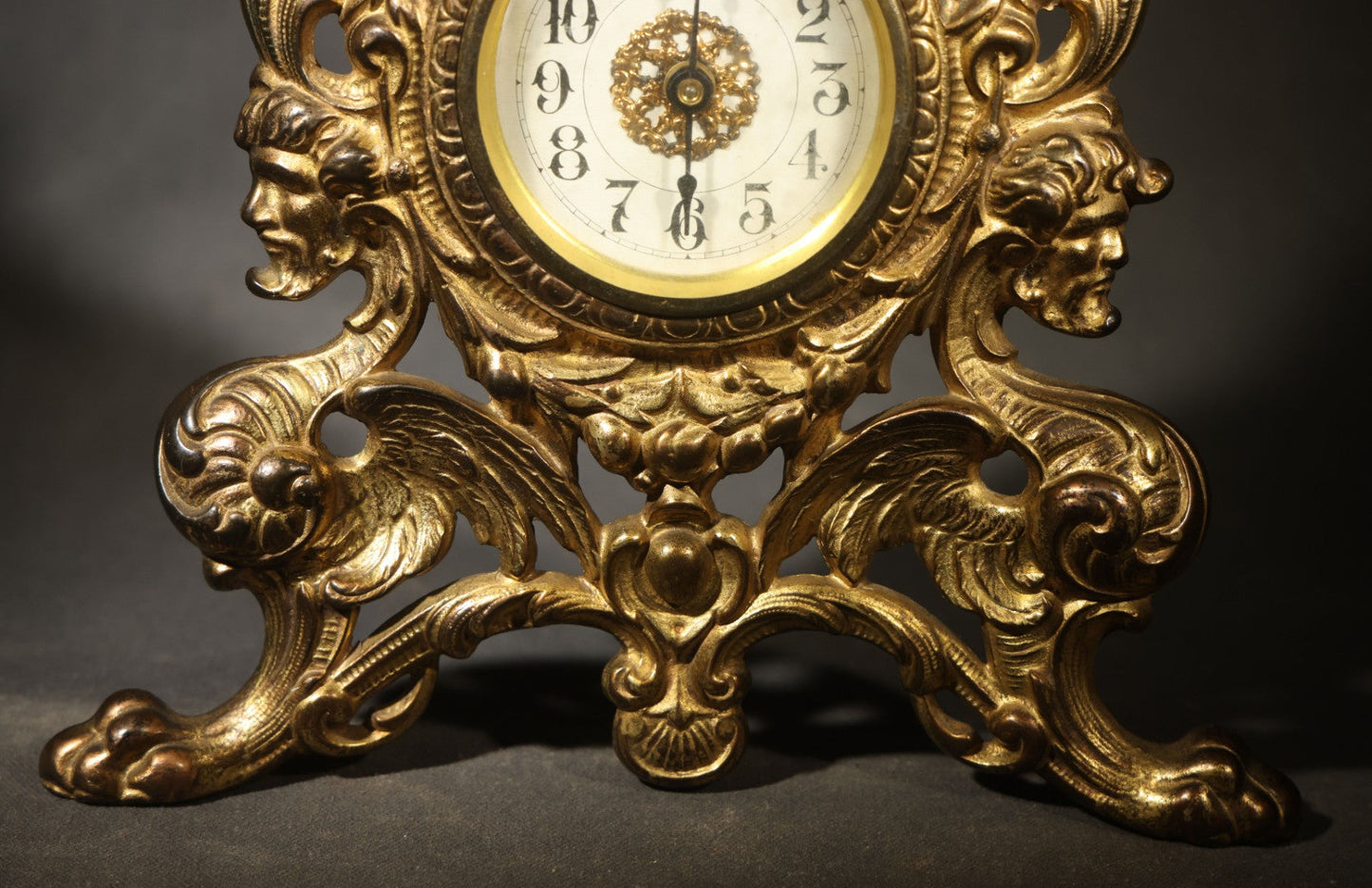 Antique Cast Brass Rococo Revival Style Mantel Clock with Winged Cherub, Grotesque Masks, and Scrolling Foliate Design, Signed A.F., Patented 1902-1908, Made in U.S.A.