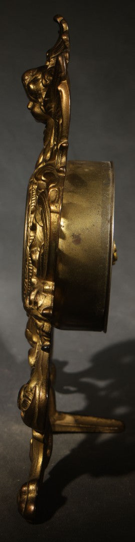 Antique Cast Brass Rococo Revival Style Mantel Clock with Winged Cherub, Grotesque Masks, and Scrolling Foliate Design, Signed A.F., Patented 1902-1908, Made in U.S.A.