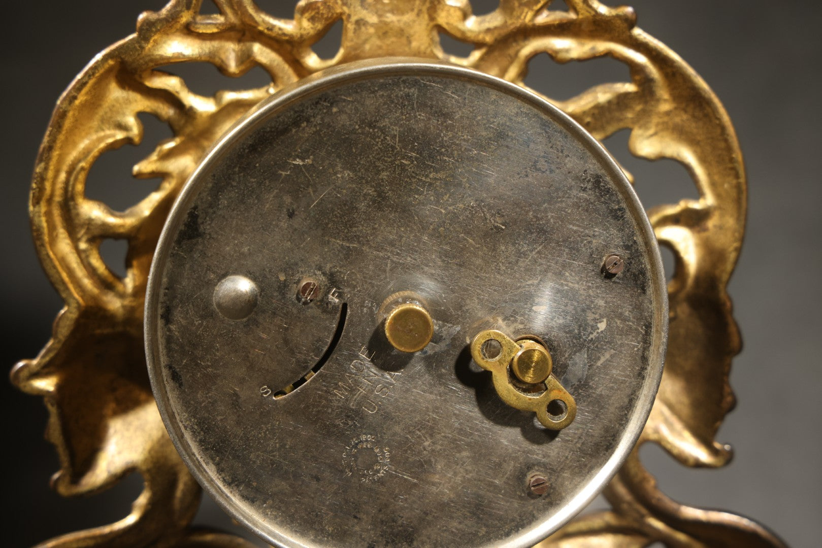 Antique Cast Brass Rococo Revival Style Mantel Clock with Winged Cherub, Grotesque Masks, and Scrolling Foliate Design, Signed A.F., Patented 1902-1908, Made in U.S.A.