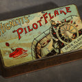 Lot 021 - Antique Hignett's "Pilot" Flake Dark Flake Cavendish Tobacco Tin with Ship's Helmsman Graphic, 5-7/8" L