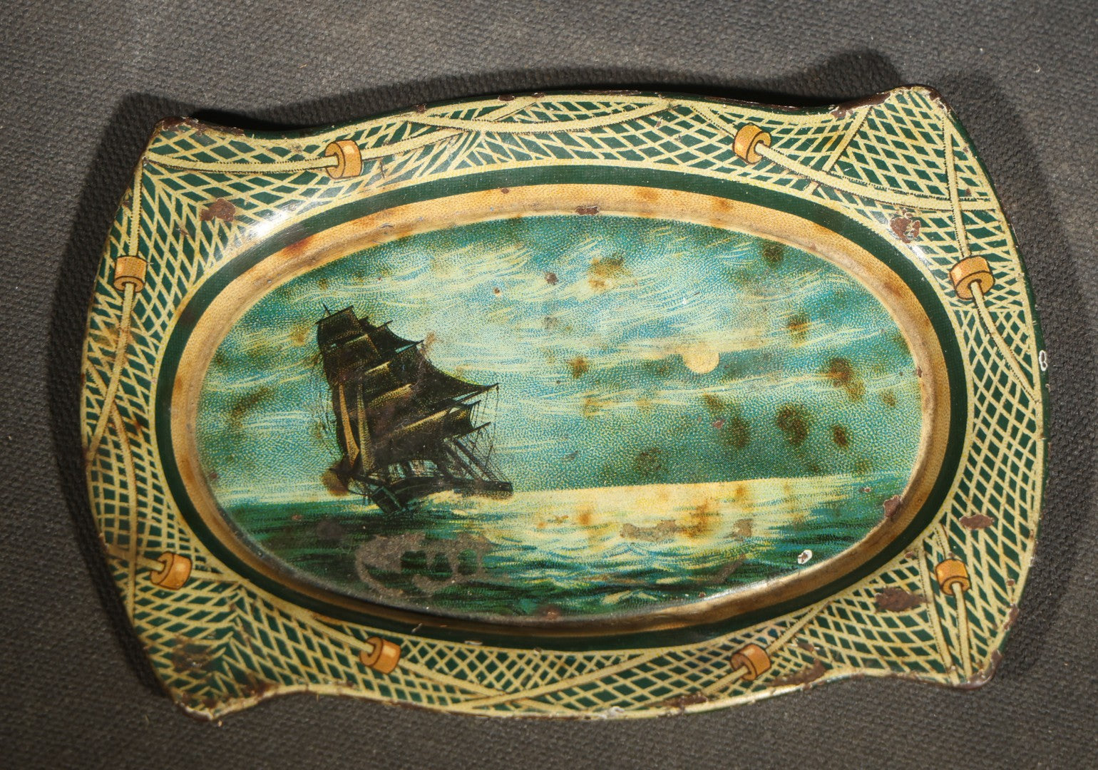 Antique Mascot Crushed Cut Tobacco Lithographed Tin Advertising Tip Tray with Sailing Ship and Fishing Net Border