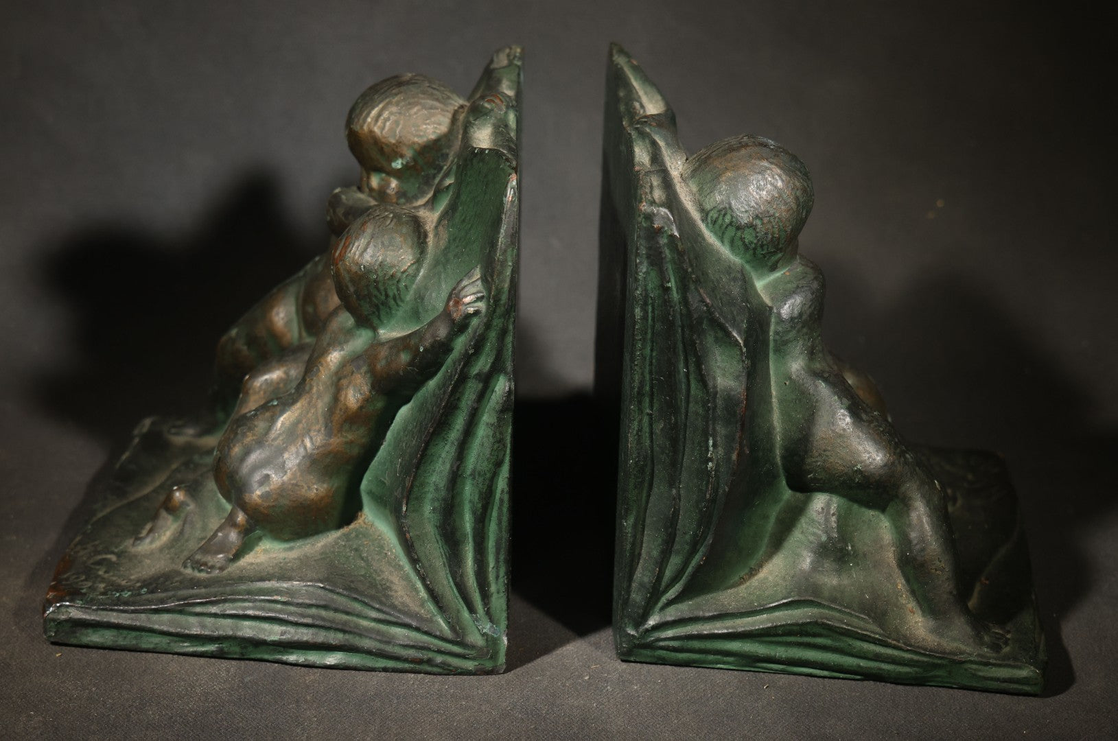 Pair of Antique Green-Patinated Bookends with Two Putti / Cherubs in Relief, Signed and Dated 1903, Manufactured by WAL Co.