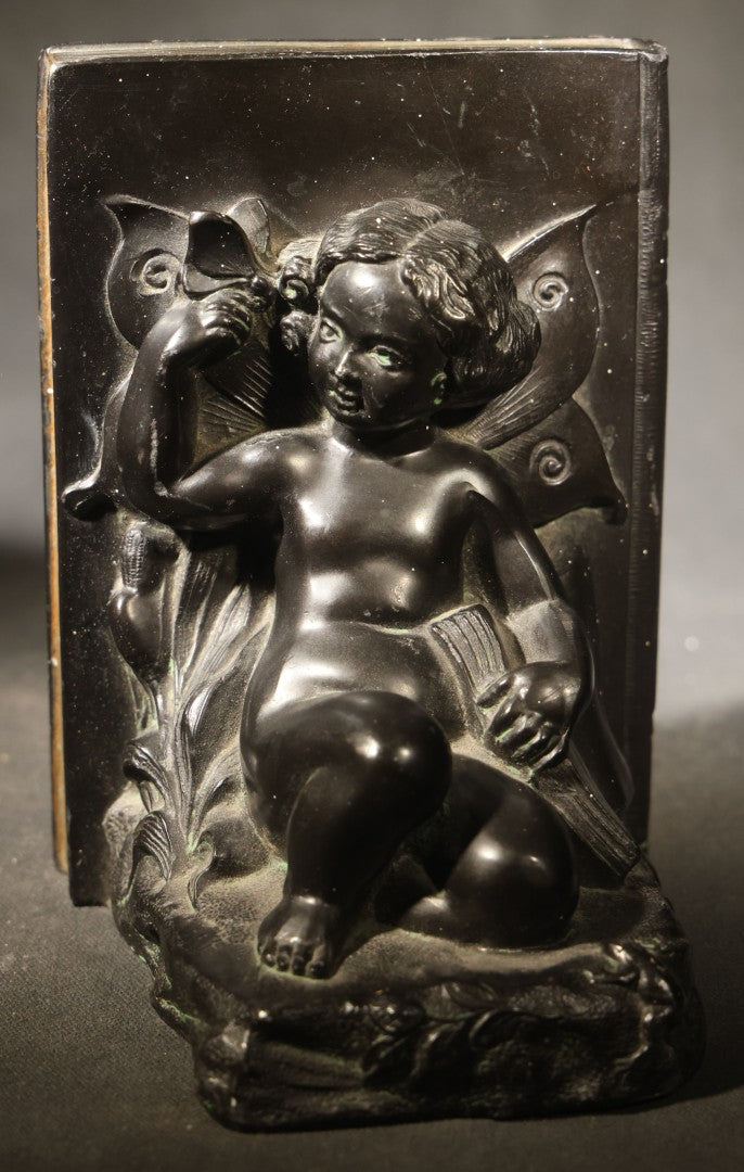 Pair of Antique Figural Bookends with Butterfly-Winged Child Seated Against Book-Form Back