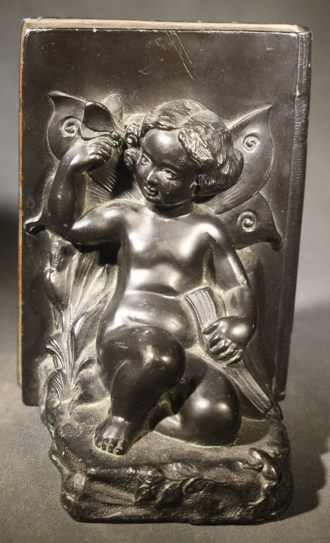 Pair of Antique Figural Bookends with Butterfly-Winged Child Seated Against Book-Form Back
