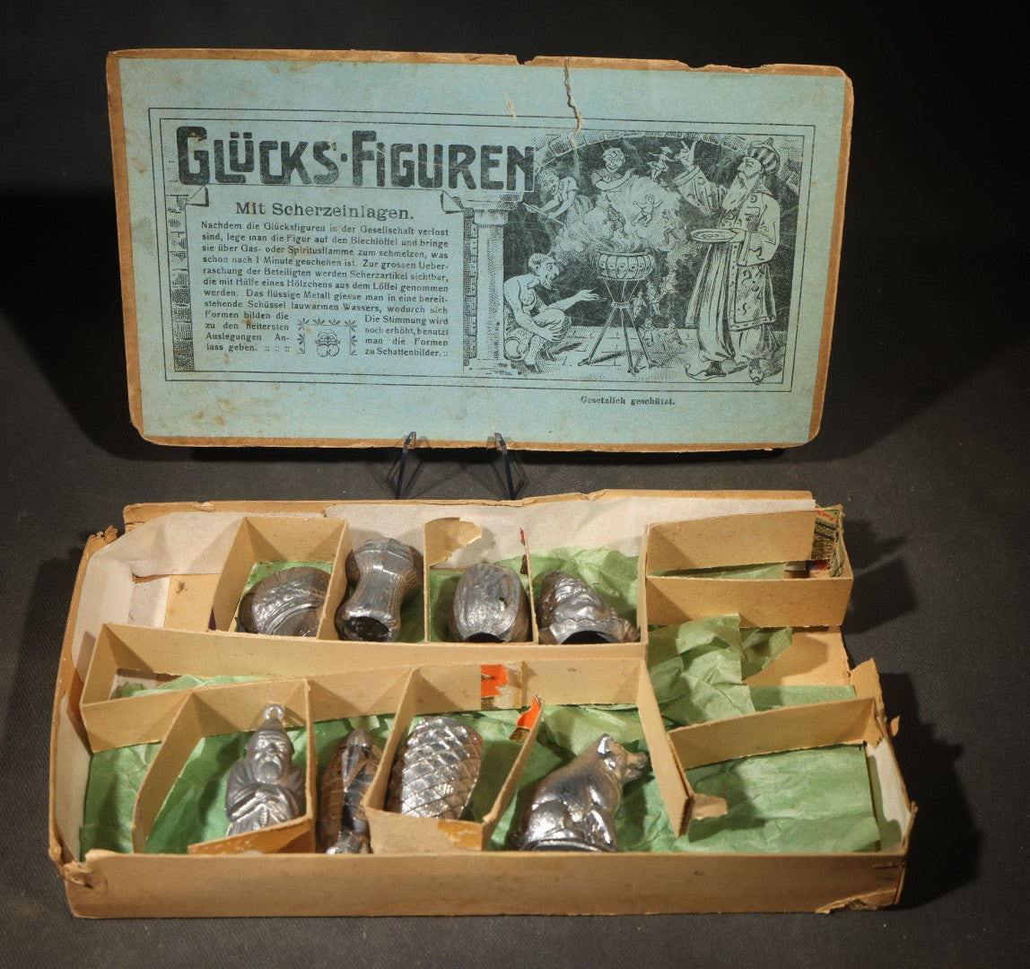 Antique German "Glücks-Figuren mit Scherzeinlagen" ("Lucky Figures with Joke Inserts") Bleigießen Fortune-Telling Set with Eight Lead Figurines including Pig, Zeppelin, Mushroom, and Wizard