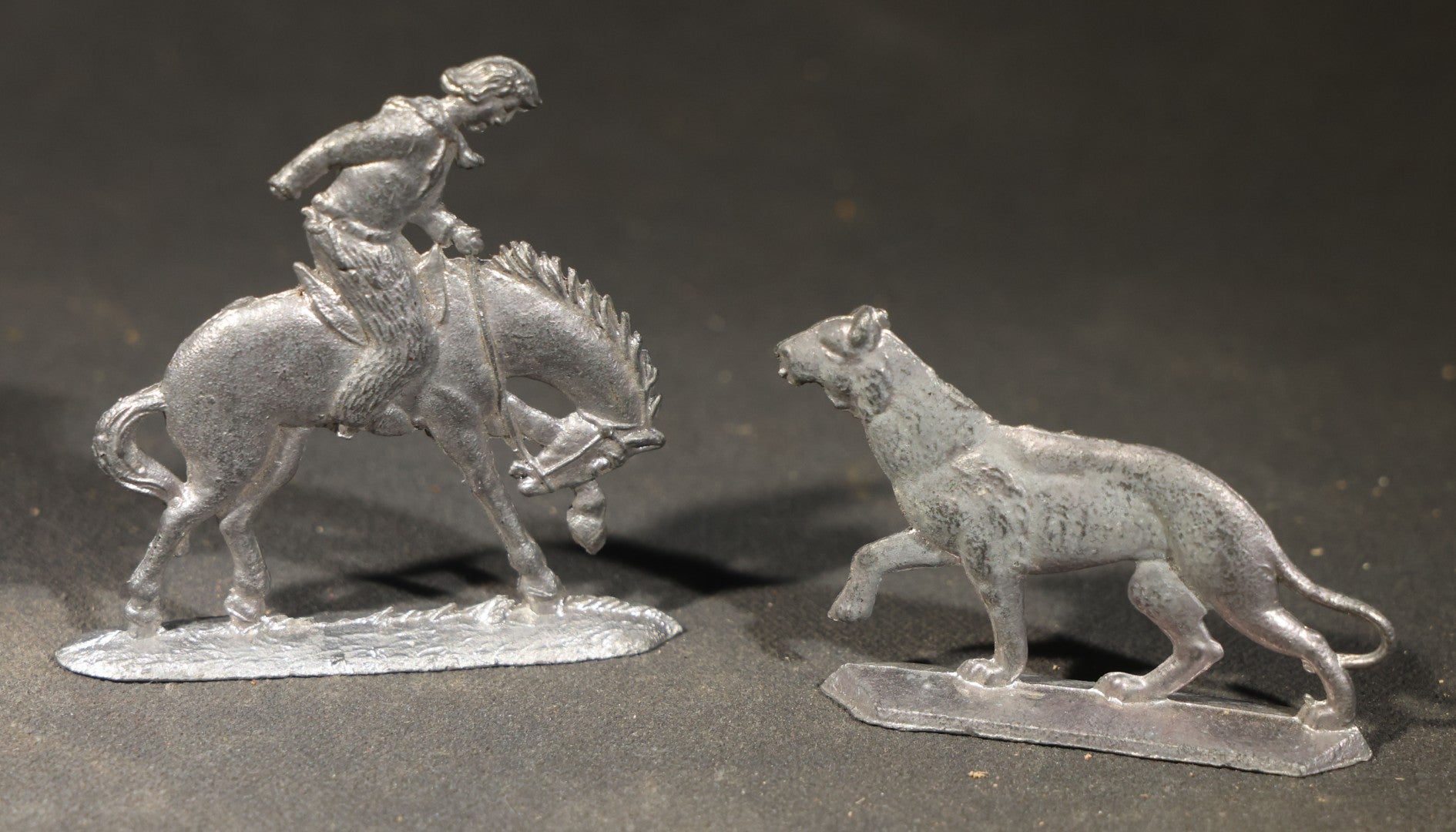 Grouping of Nine Antique German Zinnfiguren Flat Tin Figures including Camels, Lions, Bucking Bronco Rider, and Trees
