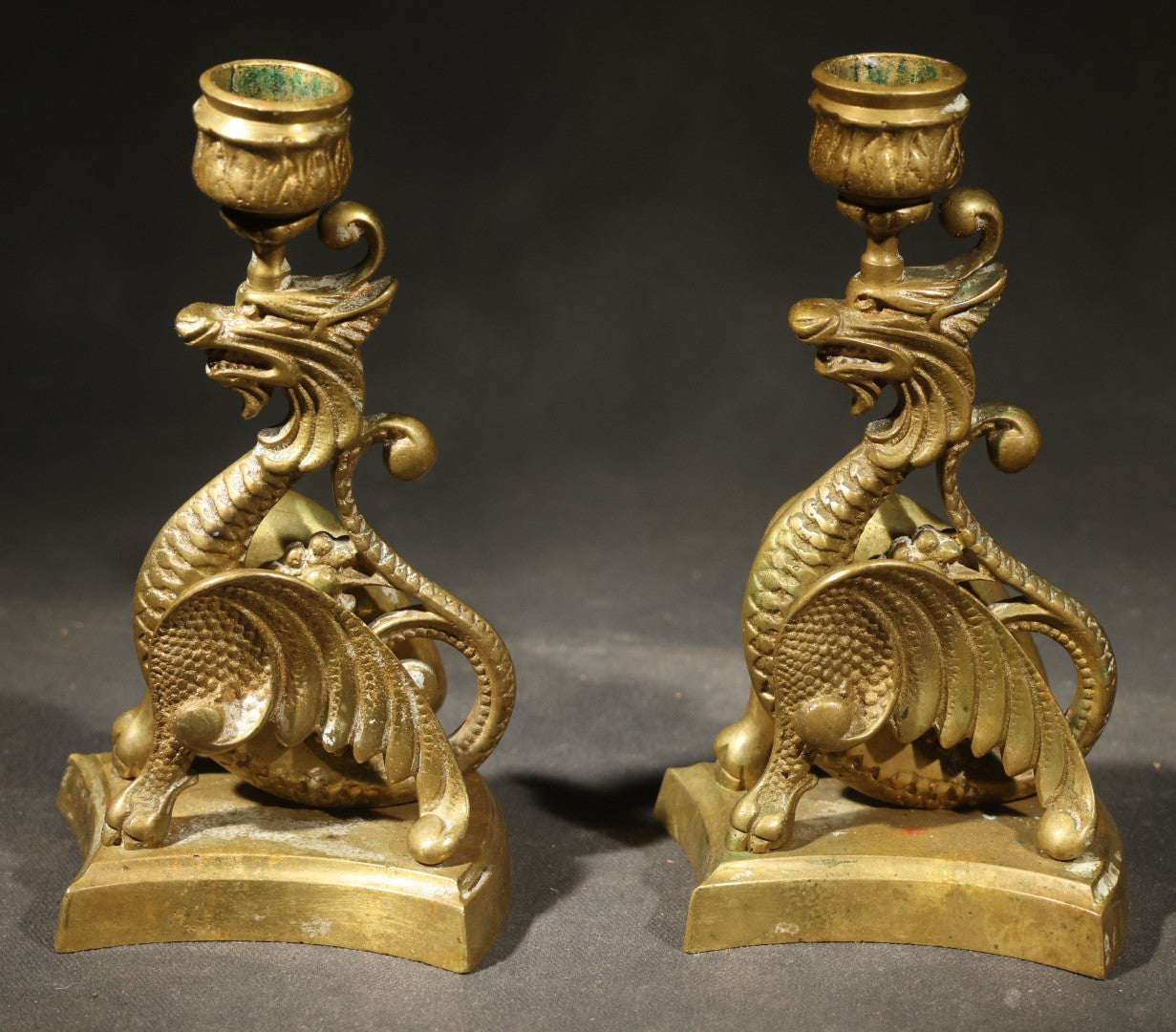 Pair of Antique Brass Figural Dragon or Griffin Candlesticks with Foliate Candle Cups on Shaped Bases