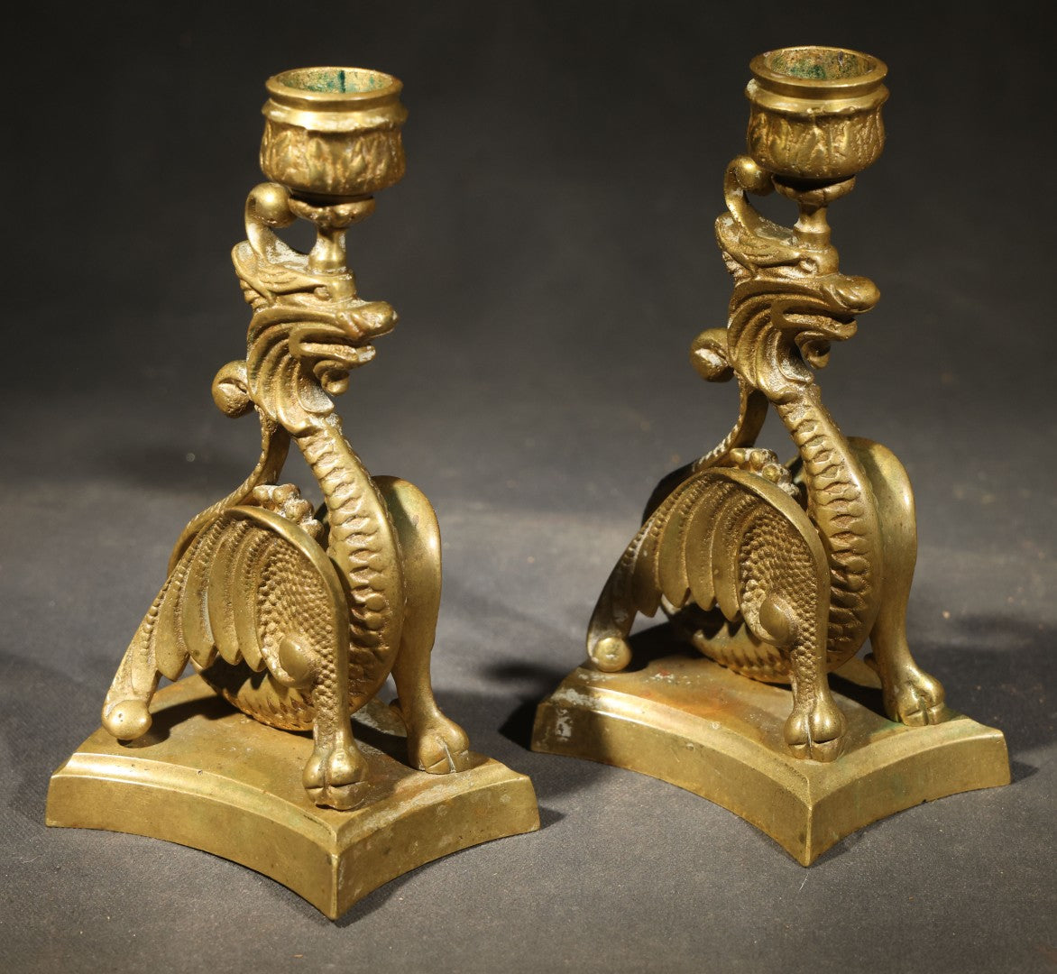 Pair of Antique Brass Figural Dragon or Griffin Candlesticks with Foliate Candle Cups on Shaped Bases