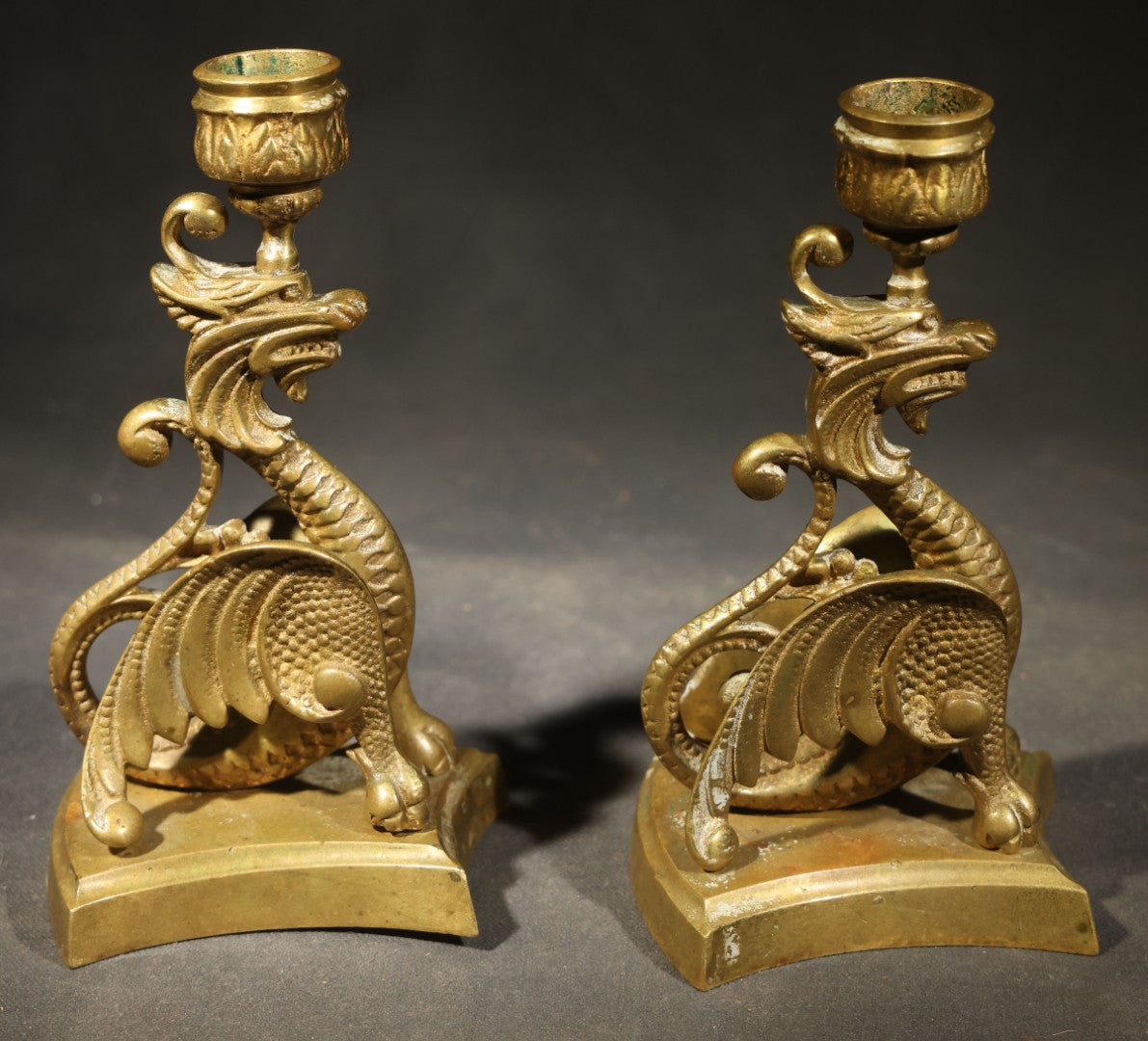 Pair of Antique Brass Figural Dragon or Griffin Candlesticks with Foliate Candle Cups on Shaped Bases