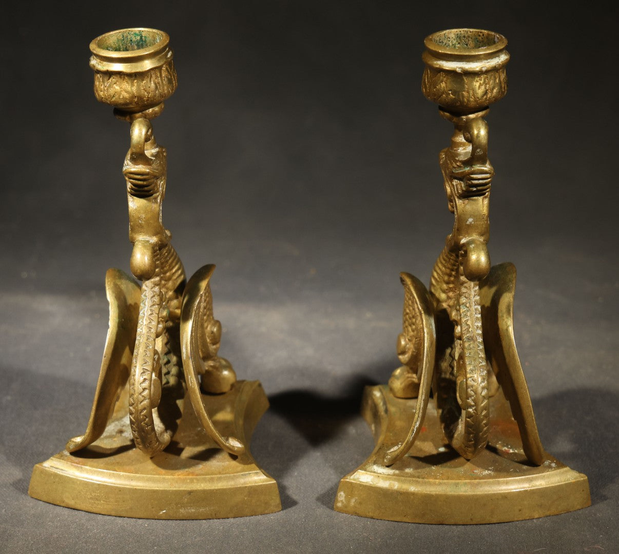 Pair of Antique Brass Figural Dragon or Griffin Candlesticks with Foliate Candle Cups on Shaped Bases