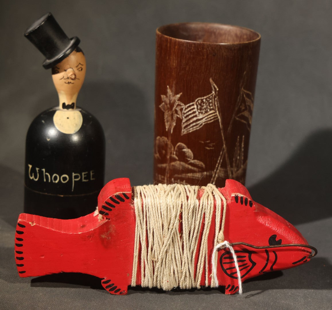 Grouping of Three Antique and Vintage Folk Art Pieces including Bamboo Cup with Crossed American and Cuban Flags, Red Painted Wooden Fish Line Winder, and "Whoopee" Man in Top Hat Figure