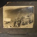 Lot 091 - Antique Board-Mounted Occupational Photograph of Eight Railroad Workers Posed Over Railroad Ties at a Hillside Camp with Frame Buildings