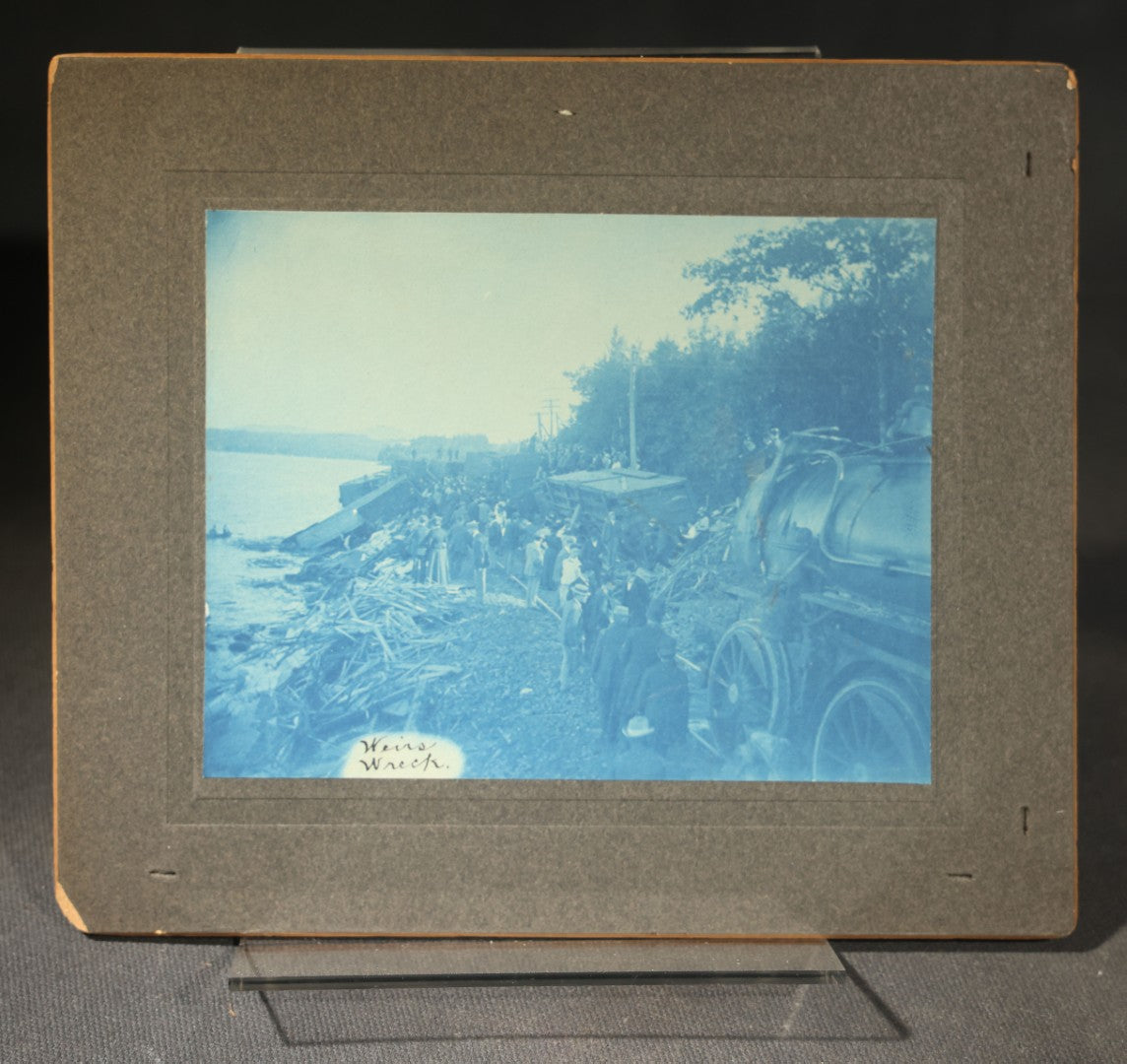 Grouping of 12 Antique Cyanotype Photographs including "Weirs Wreck" Train Derailment, Occupational Newspaper Deliveryman with "The Sun" Cart, Naval Warships, Cyanotype on Birch Bark, Man with Bicycle, and Photo Gallery Interior