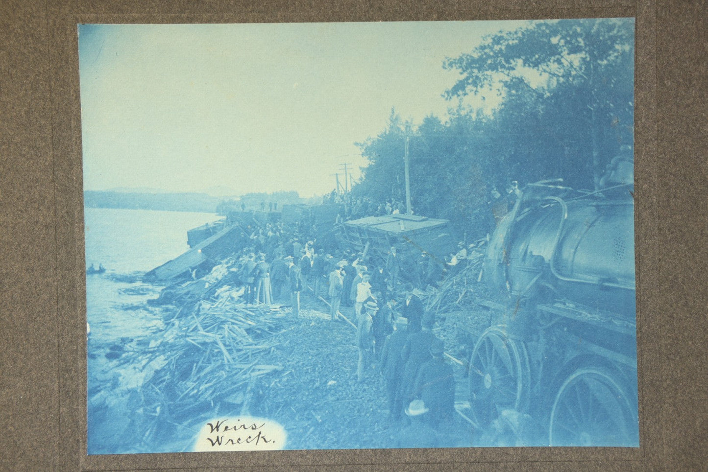 Grouping of 12 Antique Cyanotype Photographs including "Weirs Wreck" Train Derailment, Occupational Newspaper Deliveryman with "The Sun" Cart, Naval Warships, Cyanotype on Birch Bark, Man with Bicycle, and Photo Gallery Interior