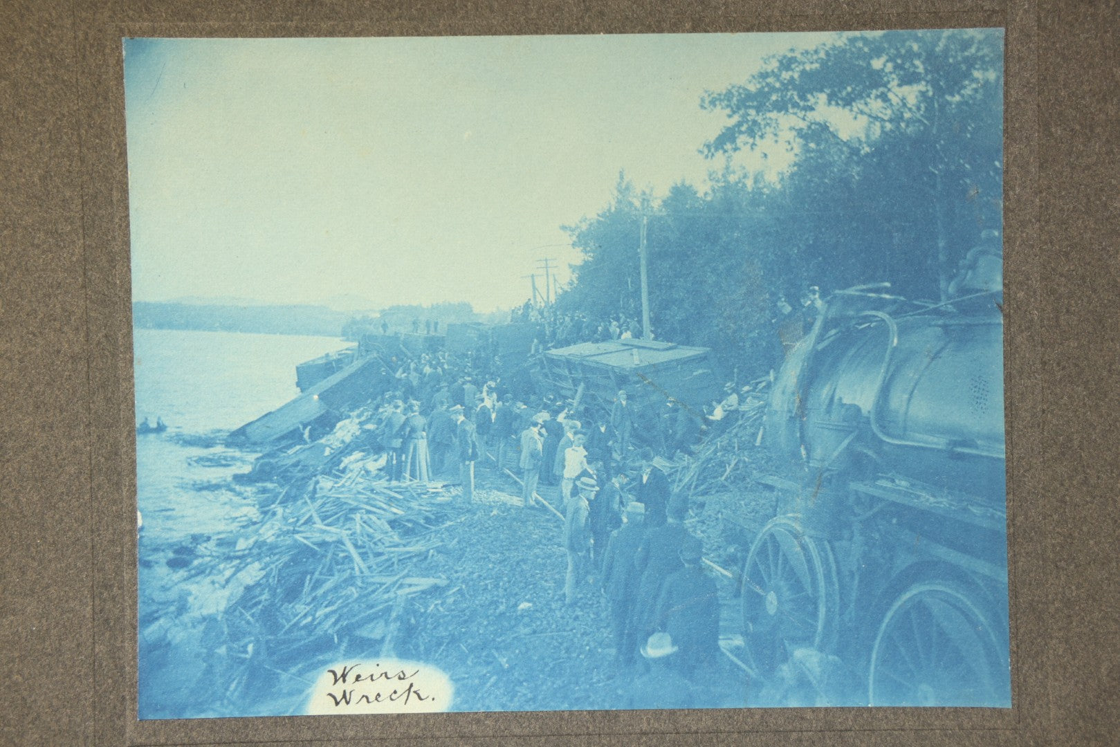 Grouping of 12 Antique Cyanotype Photographs including "Weirs Wreck" Train Derailment, Occupational Newspaper Deliveryman with "The Sun" Cart, Naval Warships, Cyanotype on Birch Bark, Man with Bicycle, and Photo Gallery Interior