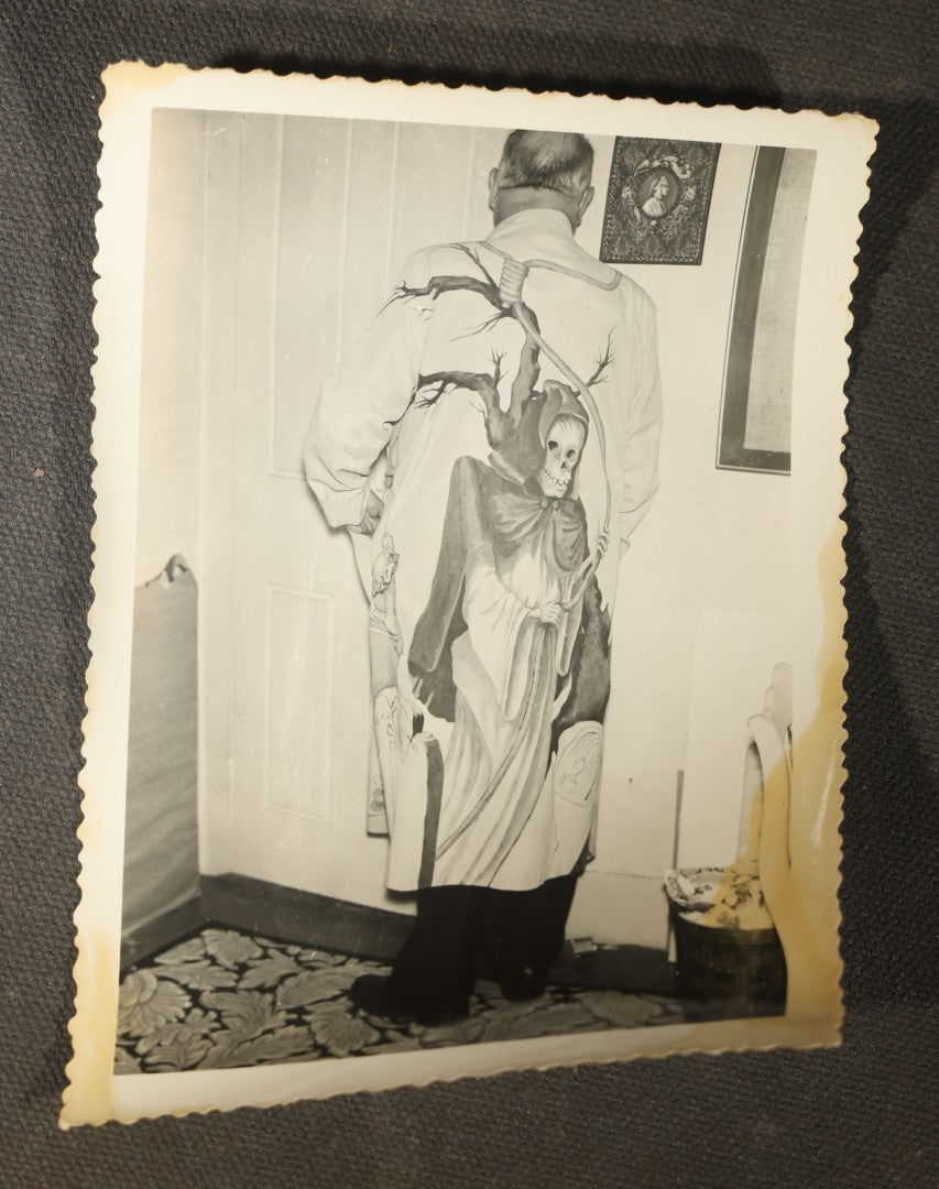 Grouping of 14 Vintage Snapshot Photographs of Costumes, Masks, and Oddities including Grim Reaper Painted Smock, Barber Shop Gag Scene, and Camp Blanding Military Stunt