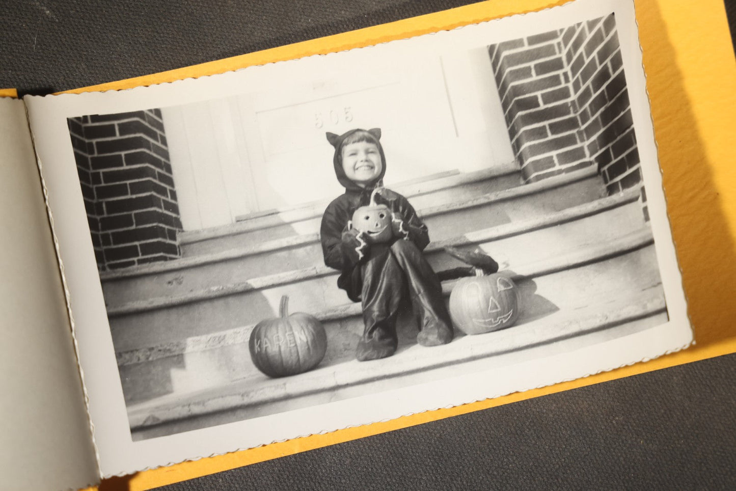 Vintage Halloween Snapshot Photo Album of a Child in Black Cat Costume with Jack-O-Lanterns and Carved Pumpkins, October 1952, Woodman Photo