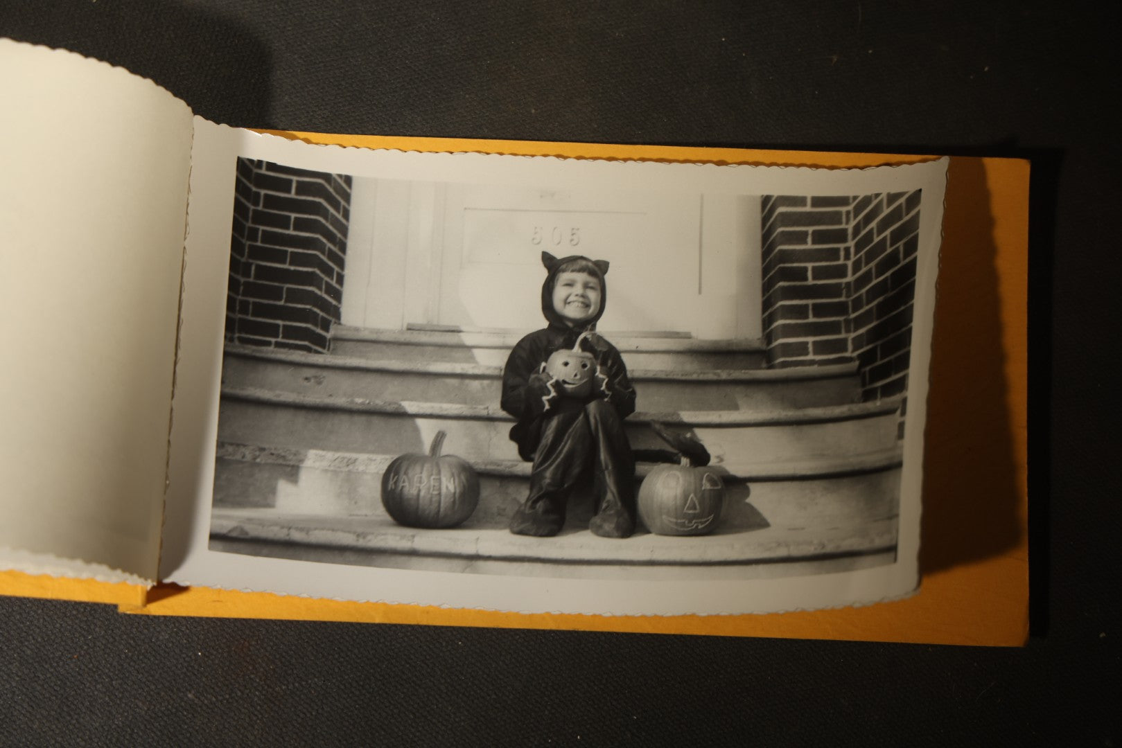 Vintage Halloween Snapshot Photo Album of a Child in Black Cat Costume with Jack-O-Lanterns and Carved Pumpkins, October 1952, Woodman Photo