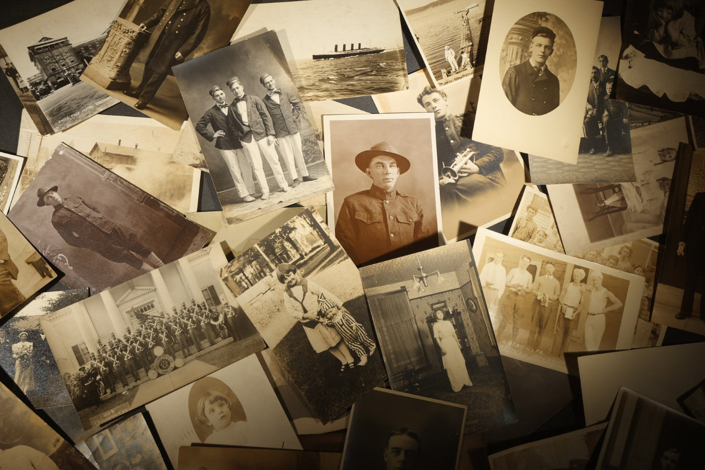 Grouping of approximately 40 Antique Real Photo Postcards R.P.P.C. including Military Soldier Portrait, Ocean Liner, Marching Band, and Portraits