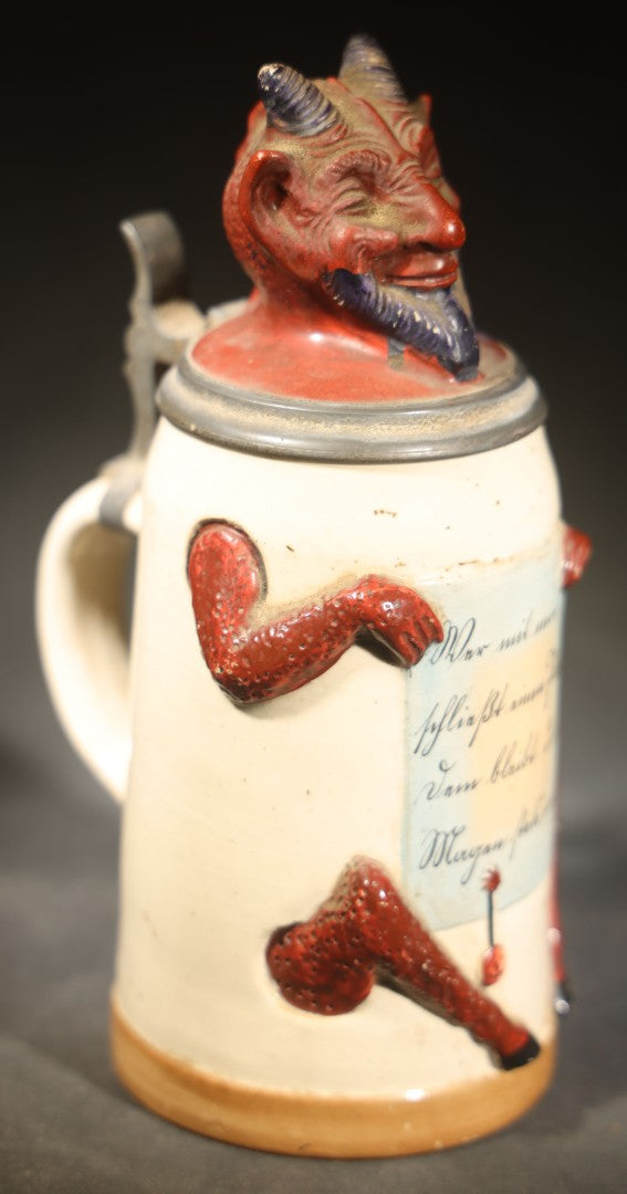Antique German Figural Devil Beer Stein with Pewter Rimmed Lid, "Wer mit mir schließt einen Pakt, dem bleibt der Magen stets intakt" ("Whoever Makes a Pact with Me, Their Stomach Will Always Remain Intact"), Mold 1565