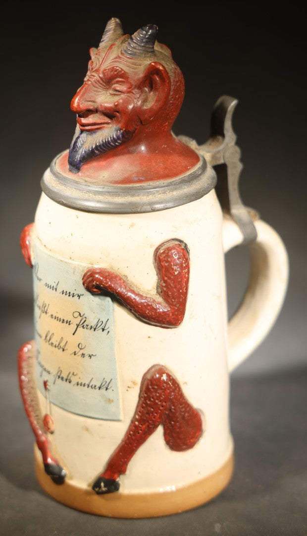 Antique German Figural Devil Beer Stein with Pewter Rimmed Lid, "Wer mit mir schließt einen Pakt, dem bleibt der Magen stets intakt" ("Whoever Makes a Pact with Me, Their Stomach Will Always Remain Intact"), Mold 1565