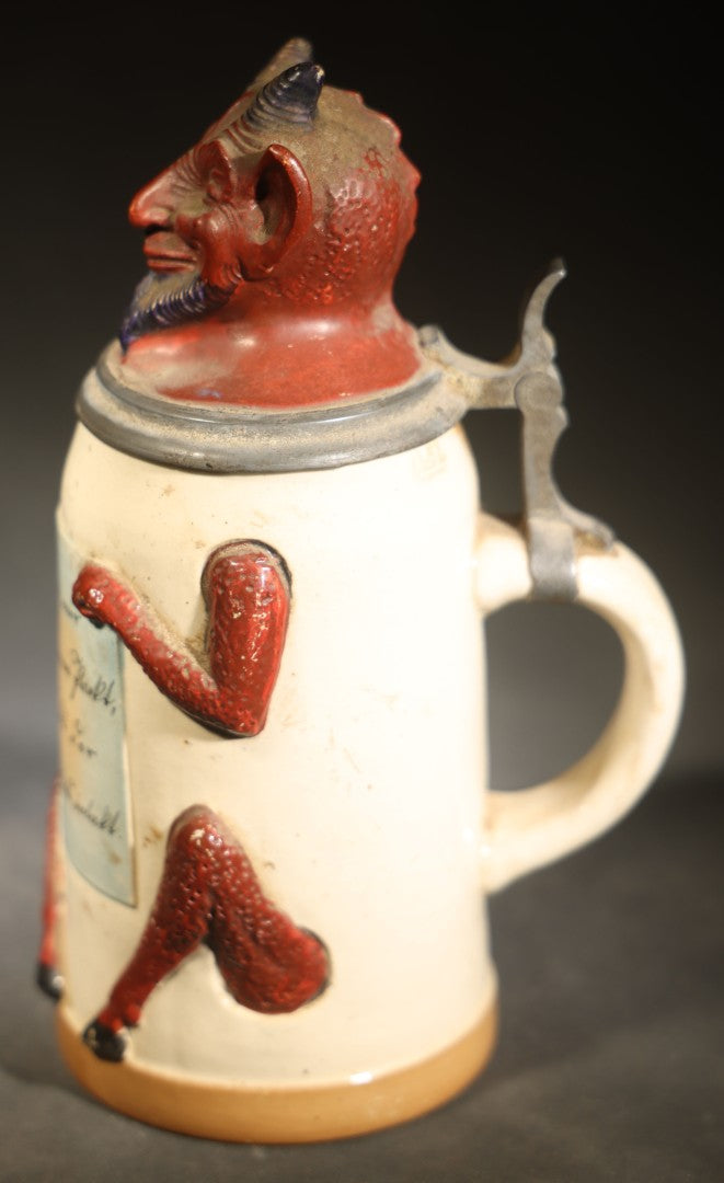 Antique German Figural Devil Beer Stein with Pewter Rimmed Lid, "Wer mit mir schließt einen Pakt, dem bleibt der Magen stets intakt" ("Whoever Makes a Pact with Me, Their Stomach Will Always Remain Intact"), Mold 1565
