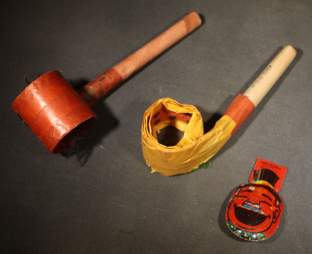 Trio of Vintage Party Favor Noisemakers including Two Halloween Paper Pipe Blowouts and Tin Lithograph Laughing Man in Top Hat Clicker, Japan