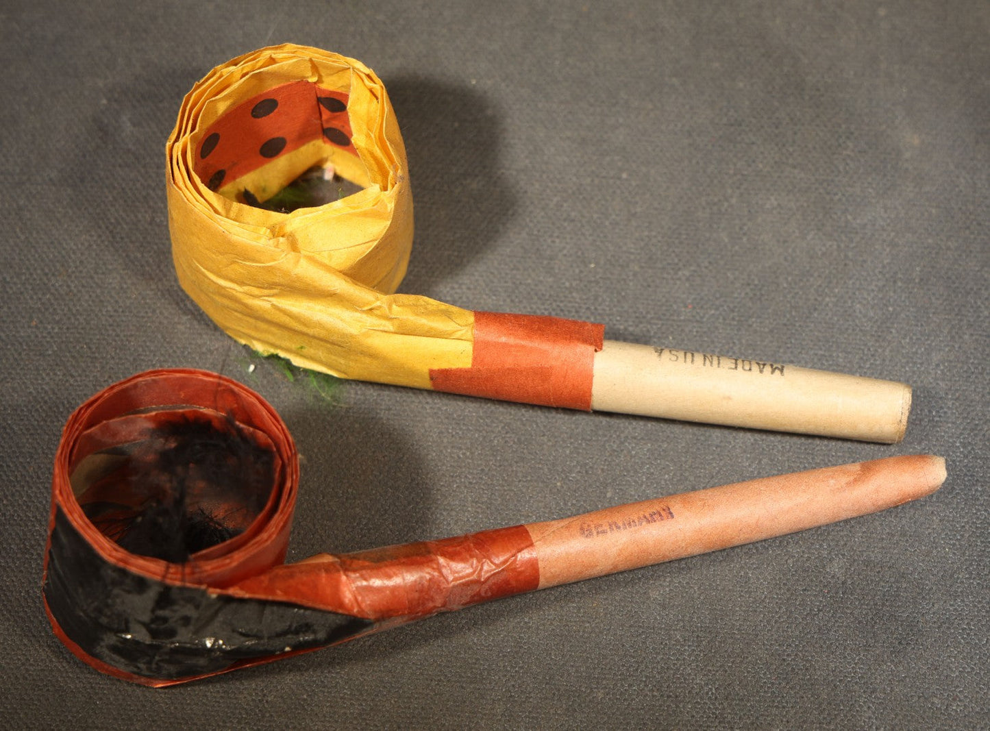 Trio of Vintage Party Favor Noisemakers including Two Halloween Paper Pipe Blowouts and Tin Lithograph Laughing Man in Top Hat Clicker, Japan