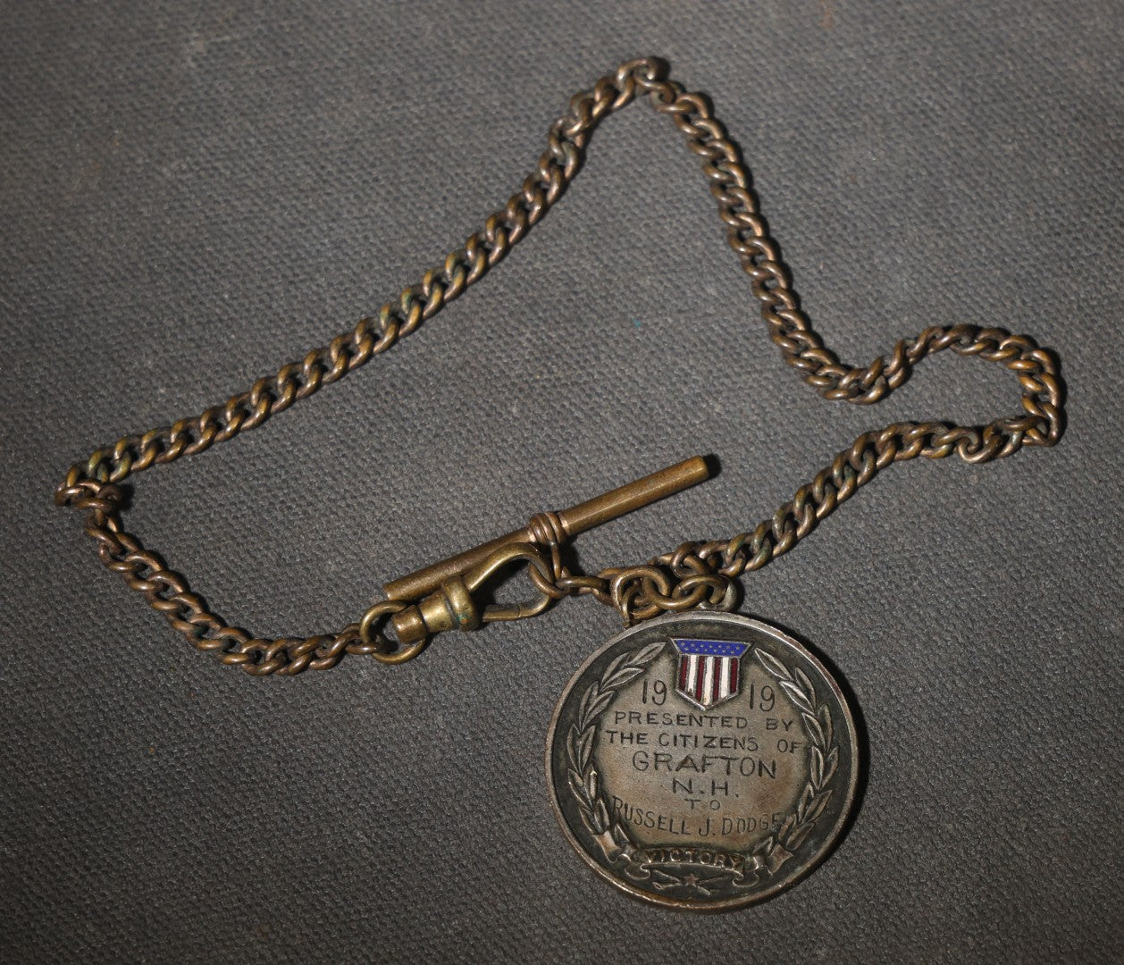 Antique World War I Victory Medal on Watch Chain, Presented by the Citizens of Grafton, New Hampshire to Russell J. Dodge, Enameled American Shield and Laurel Wreath, 1919