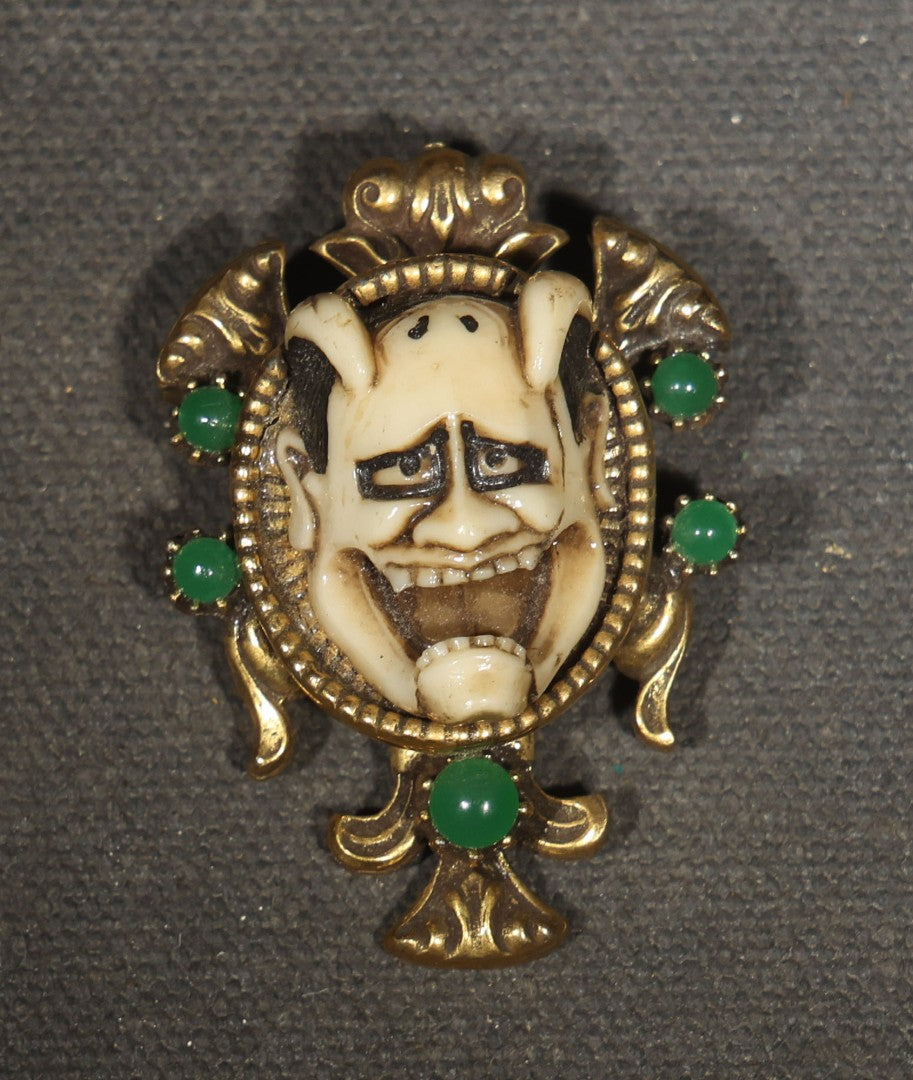 Vintage Cast Resin Japanese Hannya Mask Brooch with Green Cabochons and Gold-Tone Scrollwork Setting