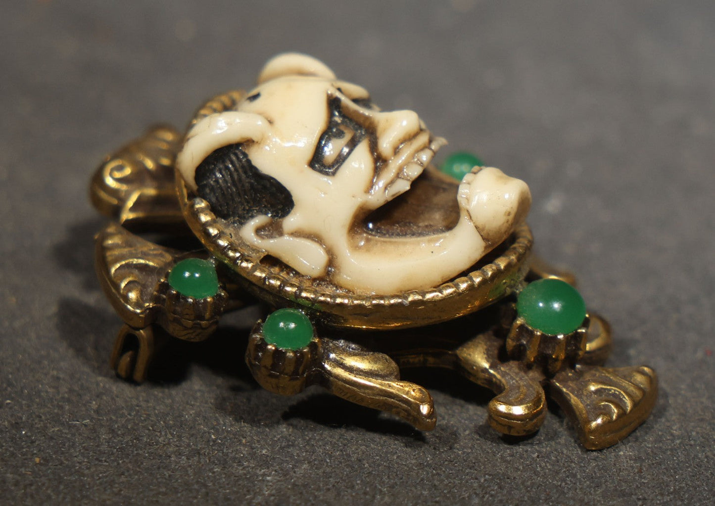 Vintage Cast Resin Japanese Hannya Mask Brooch with Green Cabochons and Gold-Tone Scrollwork Setting