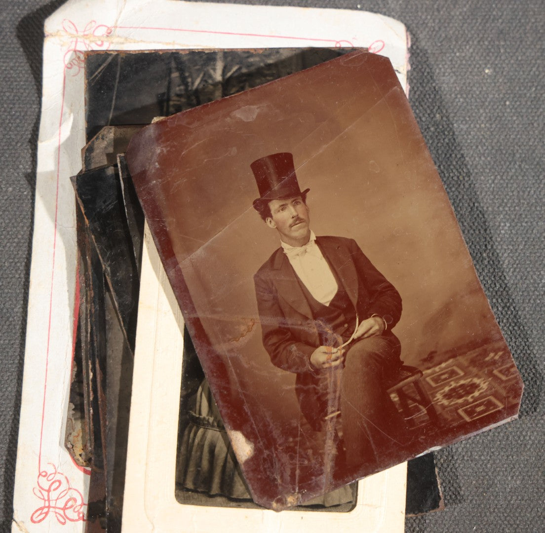 Grouping of 15 Antique Tintype Photographs including Man in Top Hat with Cane, Group of Women in White Dresses and Hats, Seated Couples, and Paper-Matted Portrait of a Seated Woman