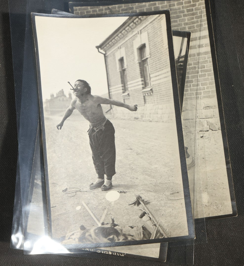 Grouping of 12 Antique Snapshot Photographs, East Asian and Russian-Language Settings including Sword Performer, Street Performer with Knife, Man with Trained Bear, Fishermen with Crabs, Construction Workers, and Children
