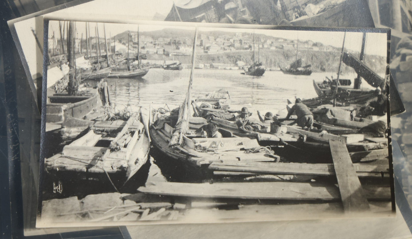 Grouping of 12 Antique Snapshot Photographs, East Asian and Russian-Language Settings including Sword Performer, Street Performer with Knife, Man with Trained Bear, Fishermen with Crabs, Construction Workers, and Children