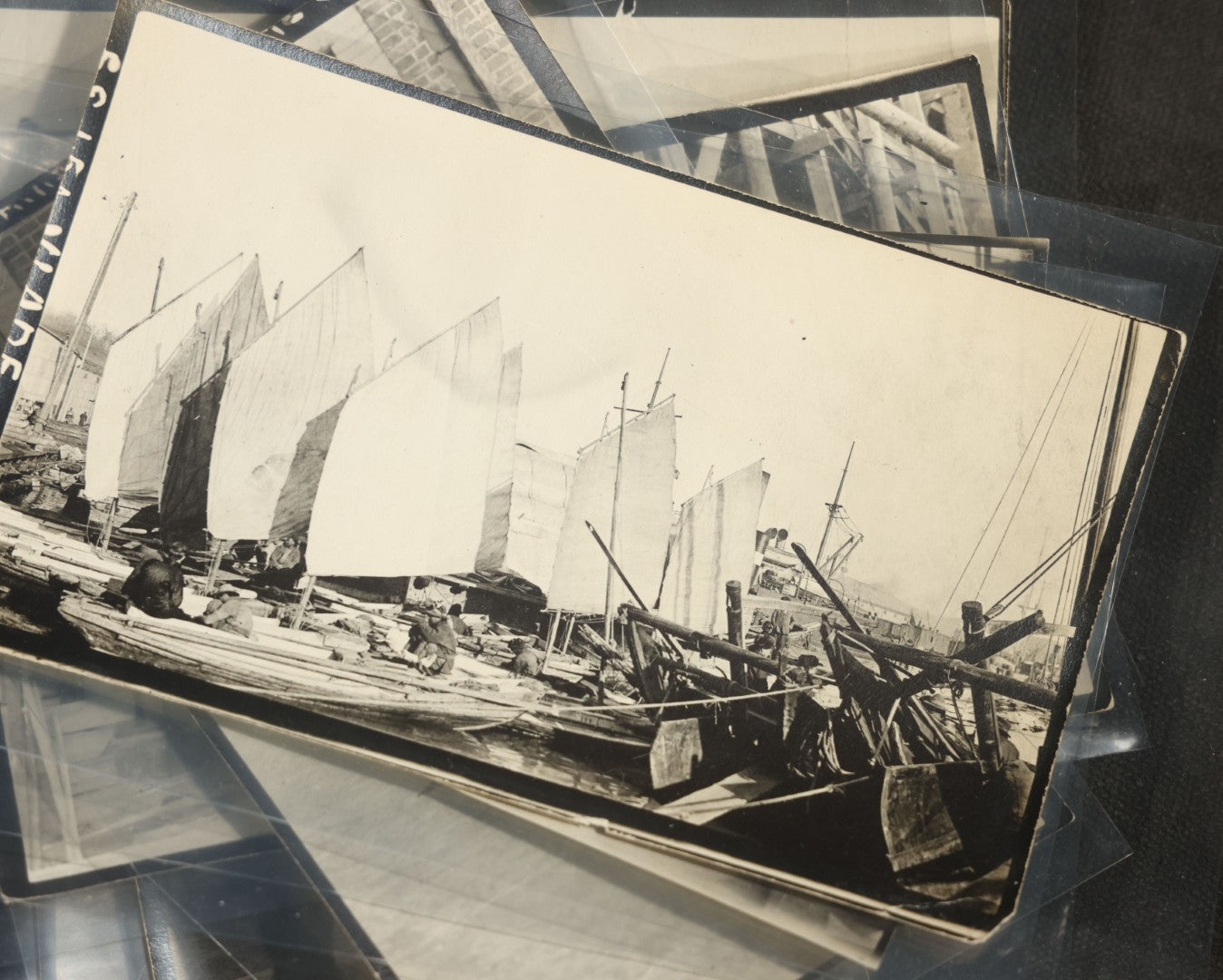Grouping of 12 Antique Snapshot Photographs, East Asian and Russian-Language Settings including Sword Performer, Street Performer with Knife, Man with Trained Bear, Fishermen with Crabs, Construction Workers, and Children