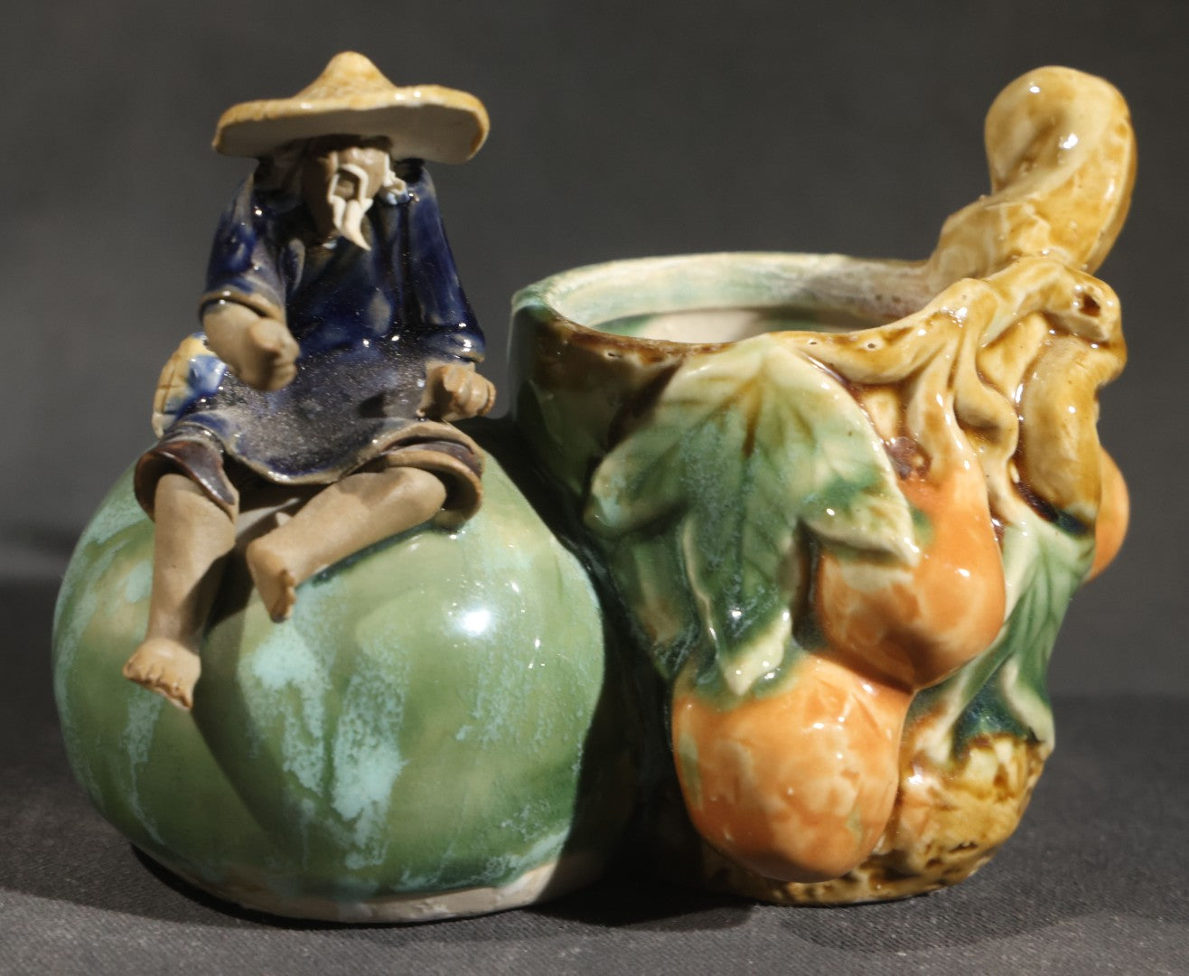 Pair of Vintage Chinese Mudman Ceramic Figurines including Seated Figure on Melon Planter and Standing Elder in Green Robe, Made in China