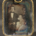 Lot 175 - Antique 1/9th Plate Daguerreotype Photograph of a Family, Man, Woman, and Child, in Brass Hanging Frame with Embossed Floral Border and Ring Loop, 2-1/4" W x 3-1/2" H