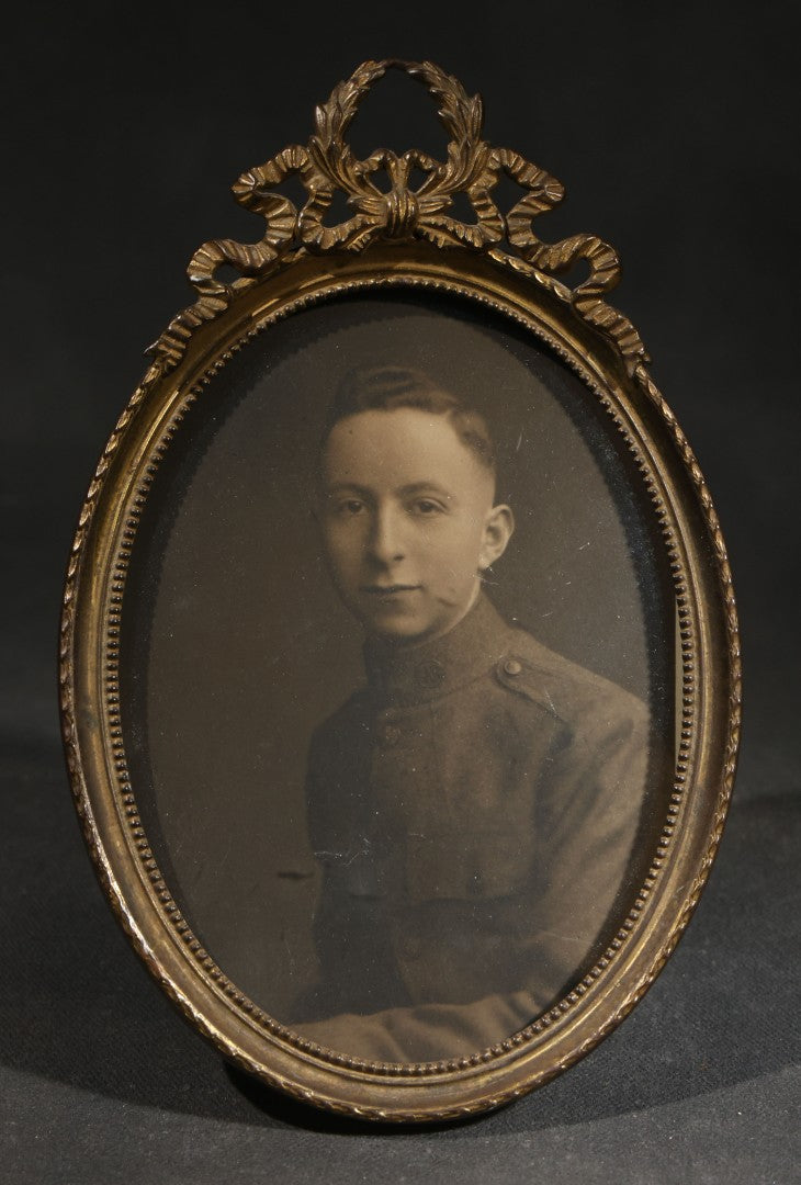 Pair of Antique Framed Oval Portrait Photographs of a Young Soldier and a Young Girl in Brass Frames with Convex Glass