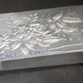 Lot 203 - Antique Aluminum Hairpin Box with Embossed Floral Design, "Where's My" With Hairpin Motif, Later-Etched "Salt Lake" Souvenir, 3-5/8" L