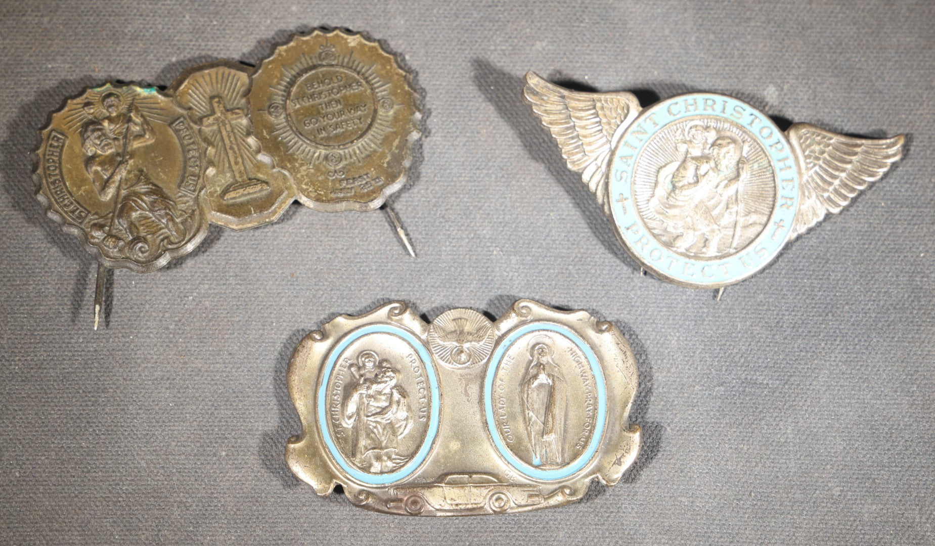 Trio of Vintage Catholic Automobile Visor Clips including Saint Christopher Winged Badge, Saint Christopher and Crucifix Three-Panel Badge, and Saint Christopher with Our Lady of the Miraculous Medal