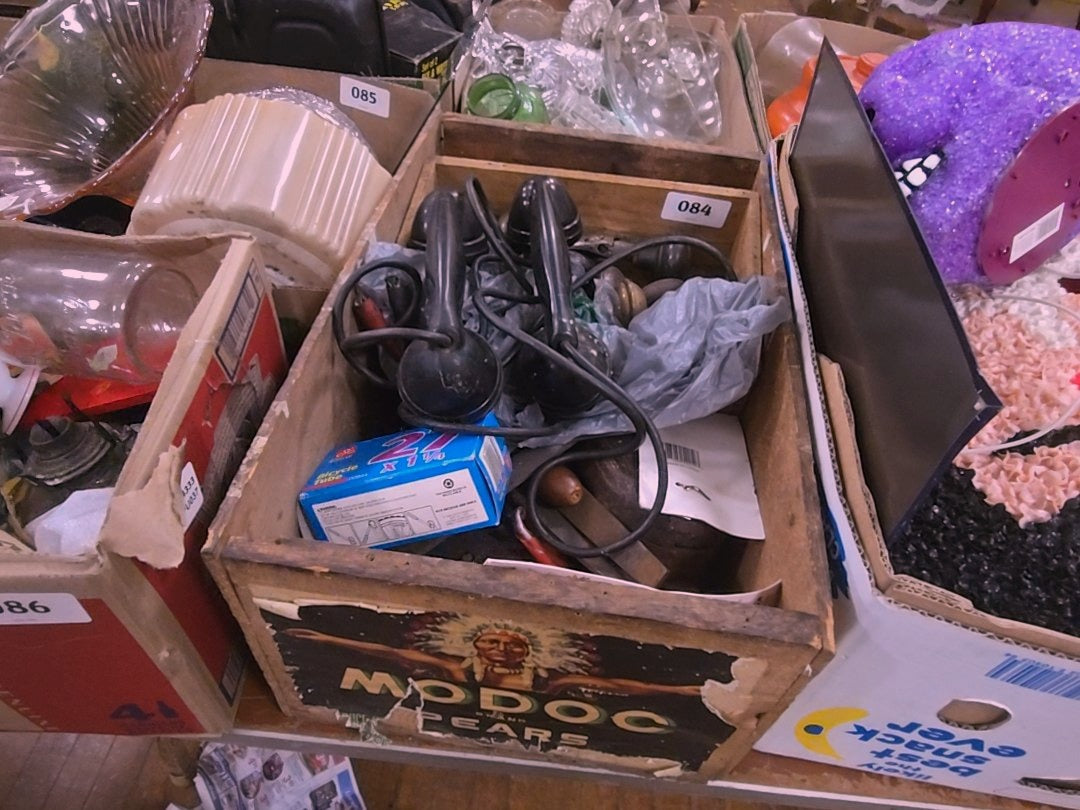 wooden crate with contents including tools and phones