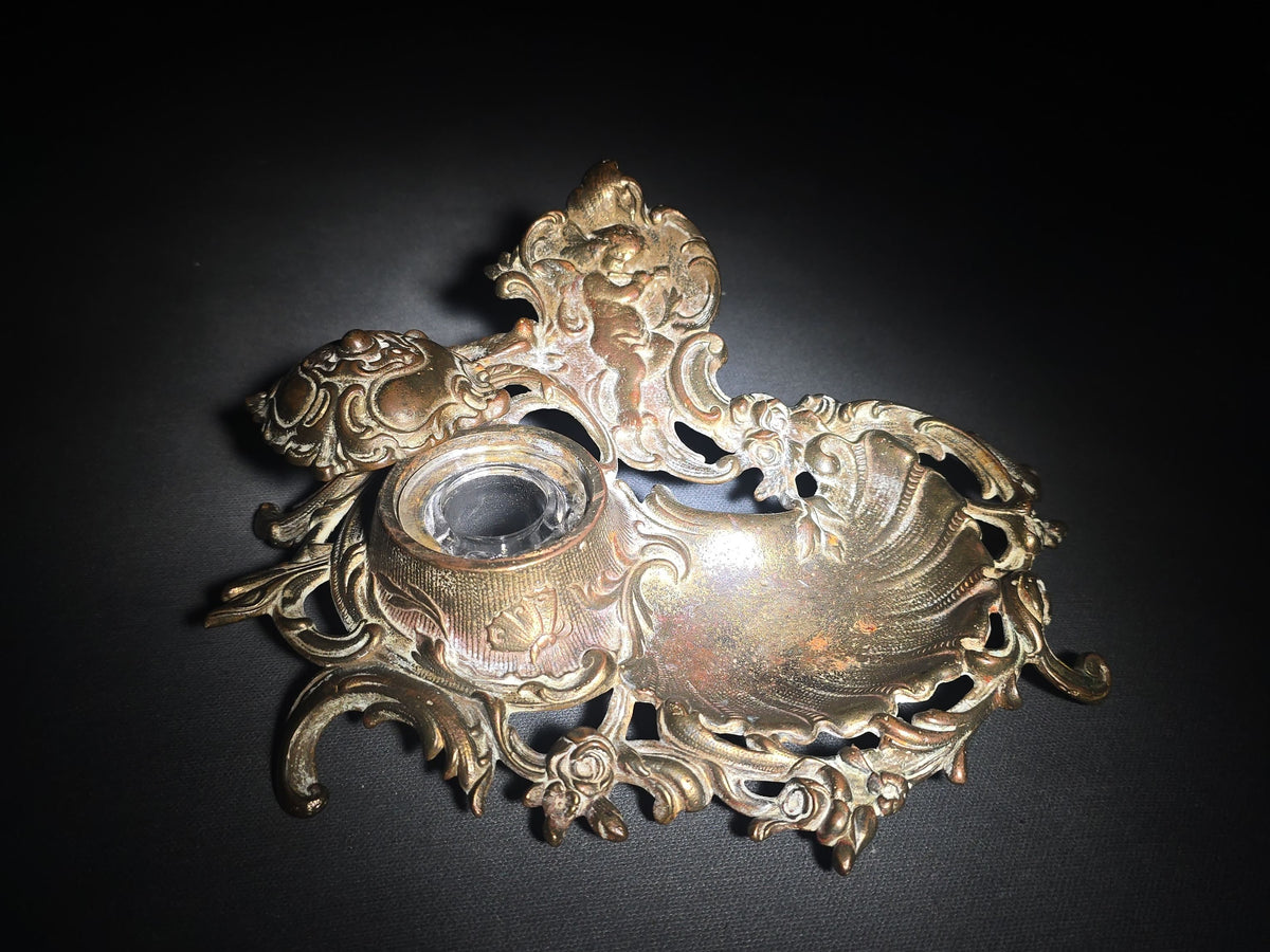 Antique Cast Metal Rococo-Style Inkstand with Cherub Finial, Glass Ink Insert, Hinged Lid, and Shell-Form Pen Tray