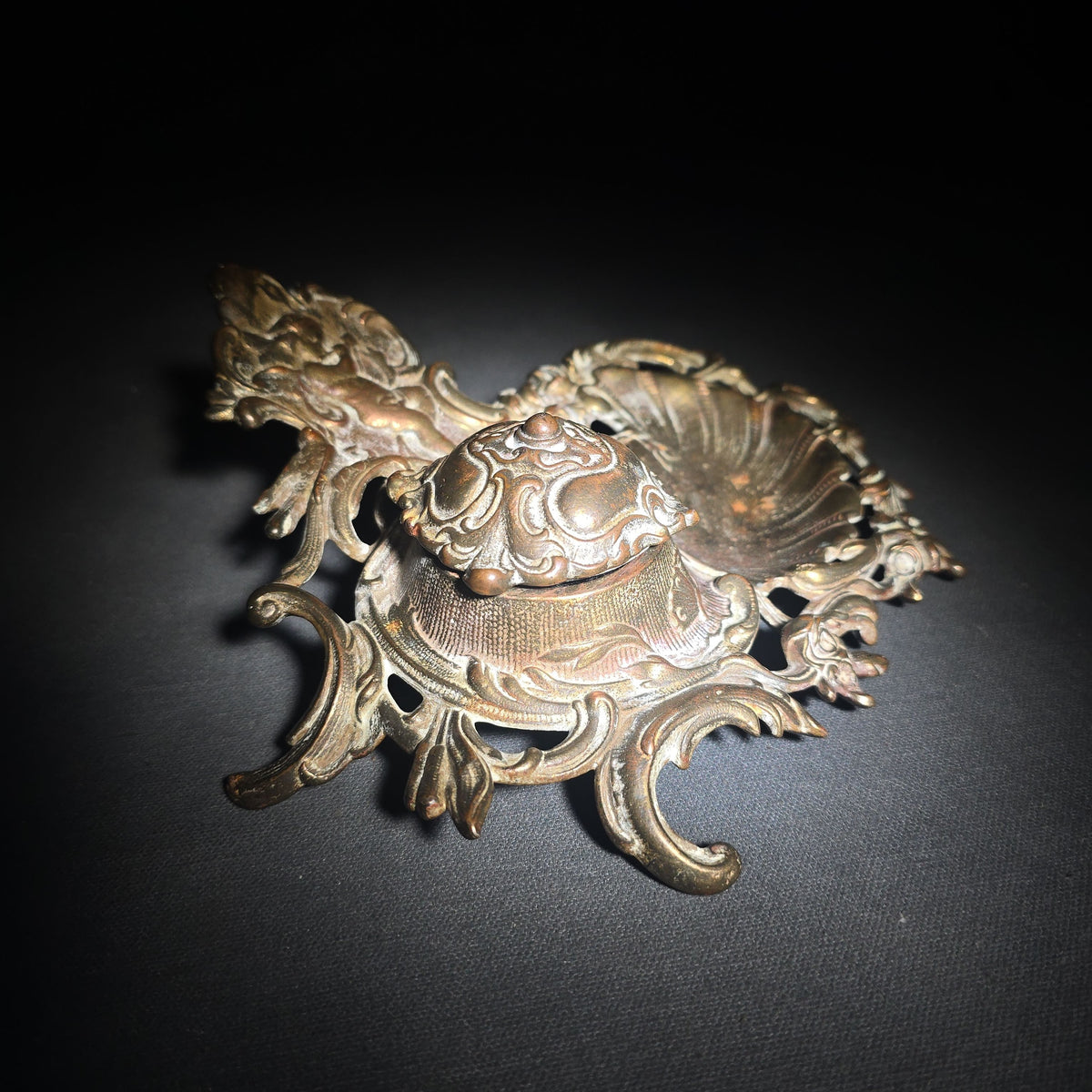 Antique Cast Metal Rococo-Style Inkstand with Cherub Finial, Glass Ink Insert, Hinged Lid, and Shell-Form Pen Tray