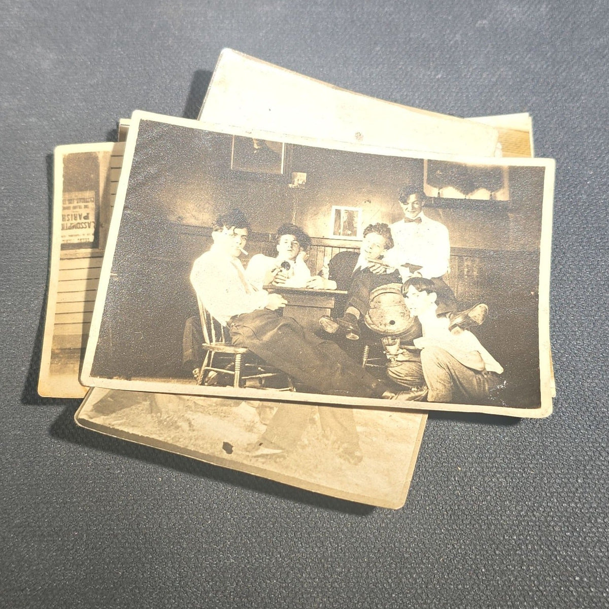 Grouping of Eight Antique and Vintage Snapshot Photographs including Boys Gambling on a Sidewalk, Clown on Stoop, Silhouette of Two Figures on a Shore, and a Group Portrait Outside