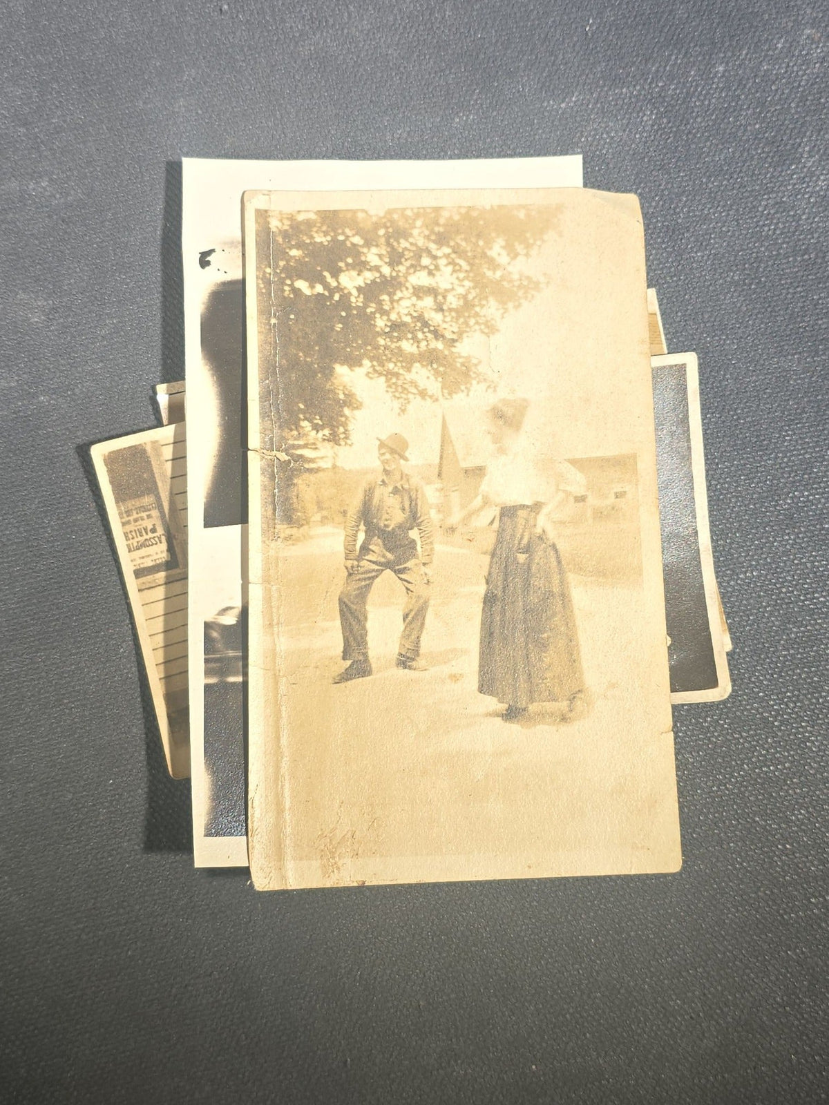 Grouping of Eight Antique and Vintage Snapshot Photographs including Boys Gambling on a Sidewalk, Clown on Stoop, Silhouette of Two Figures on a Shore, and a Group Portrait Outside