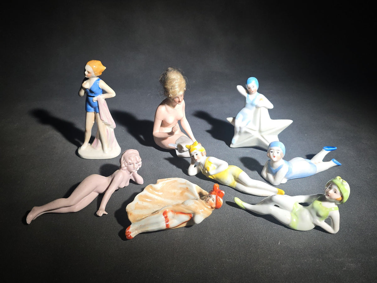Grouping of Eight Vintage Porcelain Bathing Beauty and Nude Figurines including Reclining, Seated, and Standing Poses in Swimsuits and Nude Forms