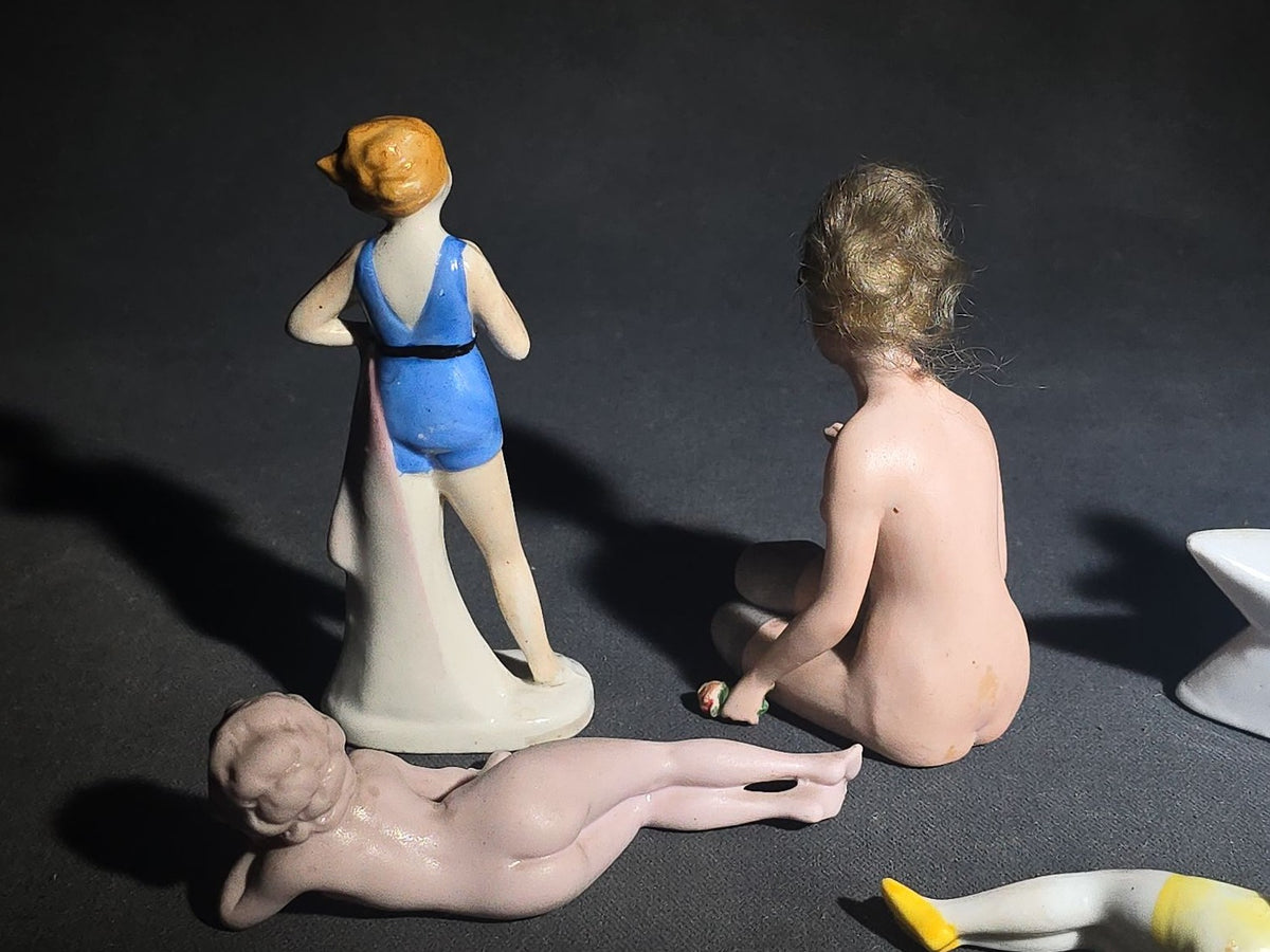 Grouping of Eight Vintage Porcelain Bathing Beauty and Nude Figurines including Reclining, Seated, and Standing Poses in Swimsuits and Nude Forms