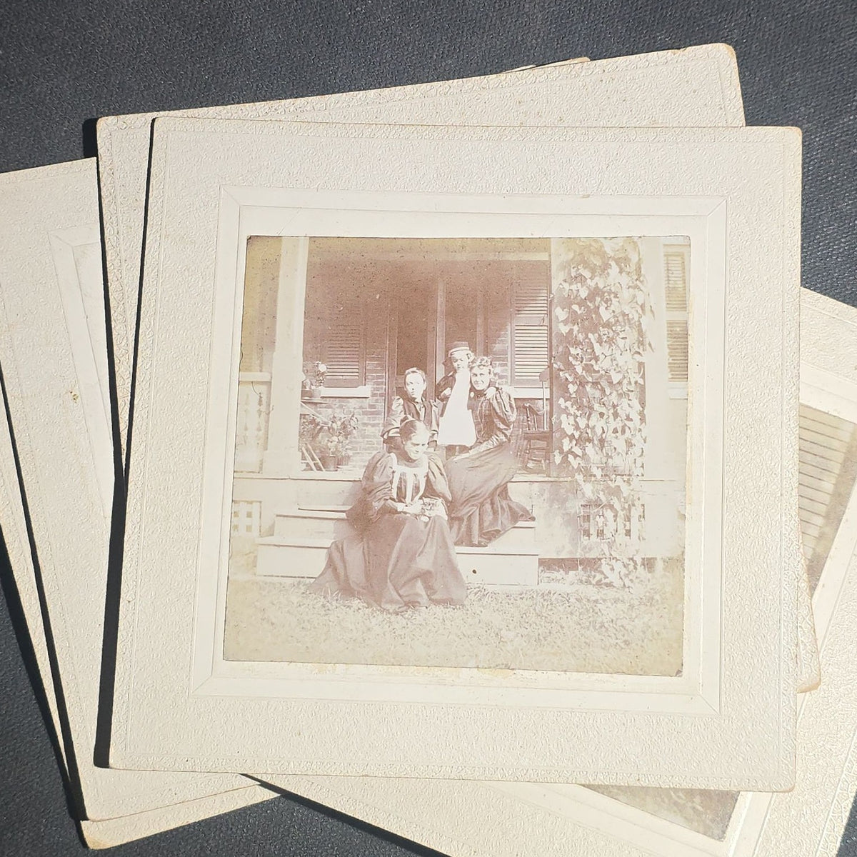 Grouping of Seven Antique Board-Mounted Photographs including Homes, Log Cabin, Children with Dog, and Band Director with Brass Instrument, Proctor, Vermont, Circa 1880s-1890s
