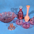 Lot 161 - Grouping of Vintage Cranberry and Pink Glass Including Ruffled Bowl, Decanter, Striped Bud Vase, Candleholder, and Lidded Jar